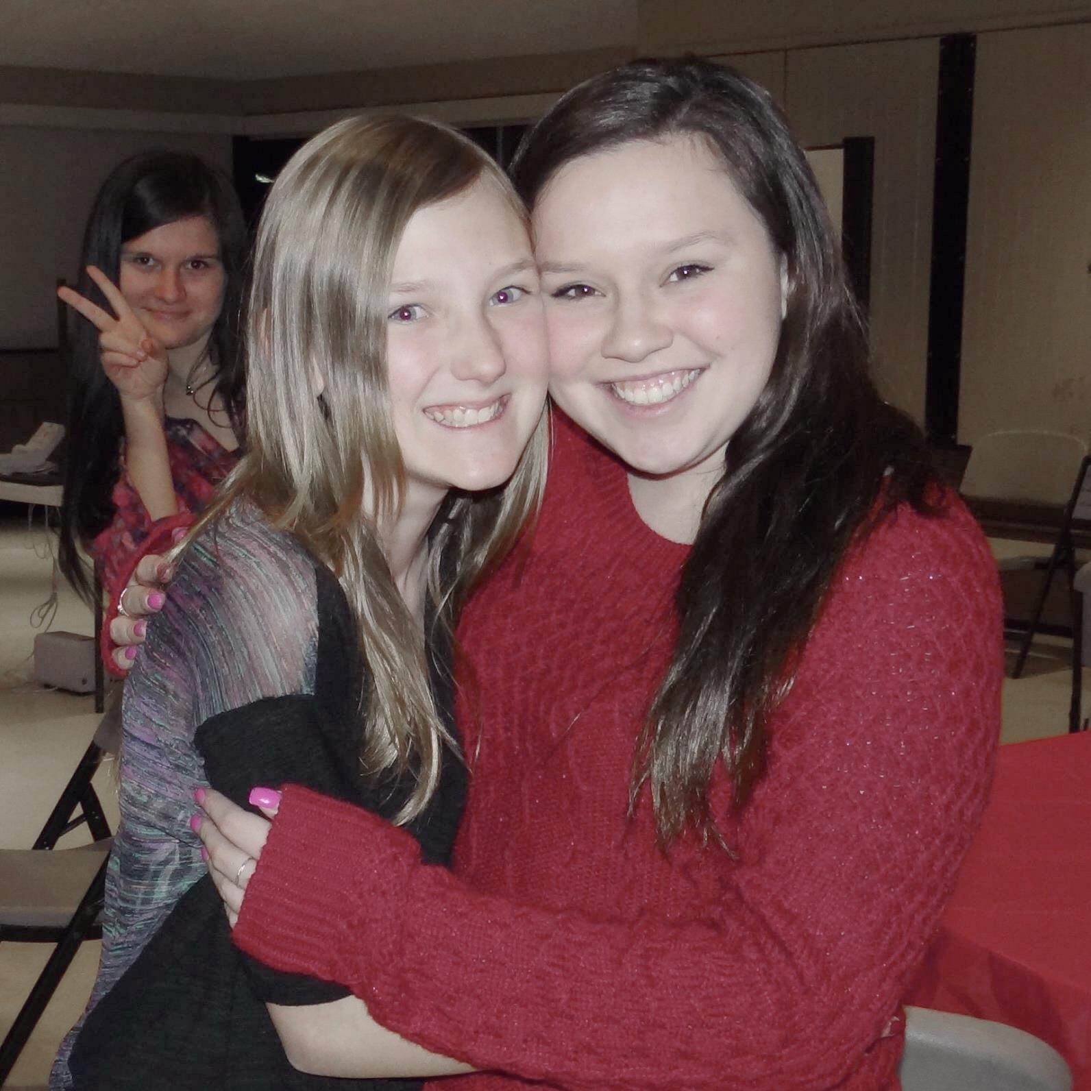 Cousin Alexis and Jenny take advantage of the annual Hansen Christmas Party to take a quick picture, while Michelle takes advantage of being unnoticed to photobomb!