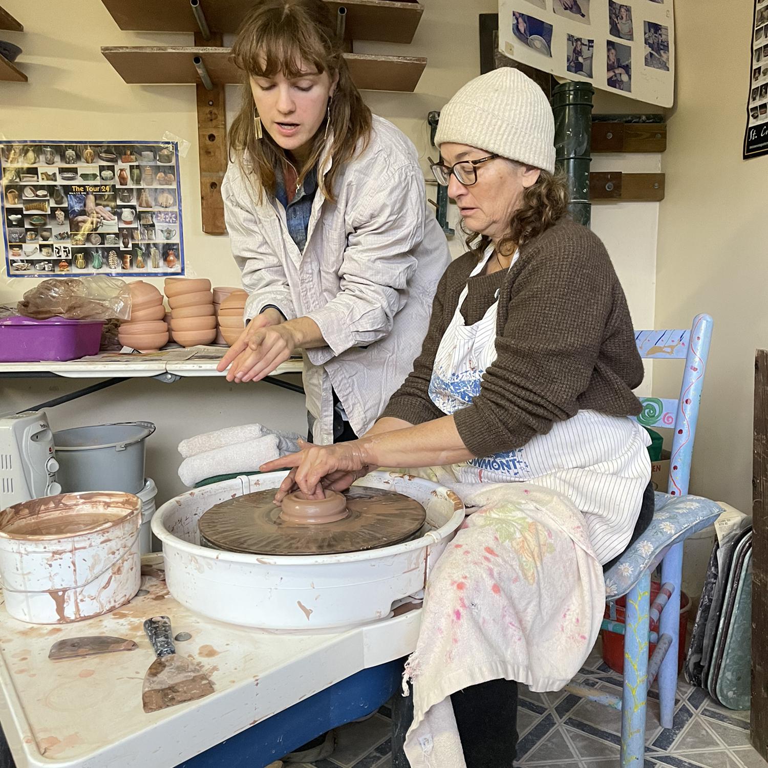 Lucy helping Lucretia throw on the wheel in Lucy’s mom’s pottery studio.