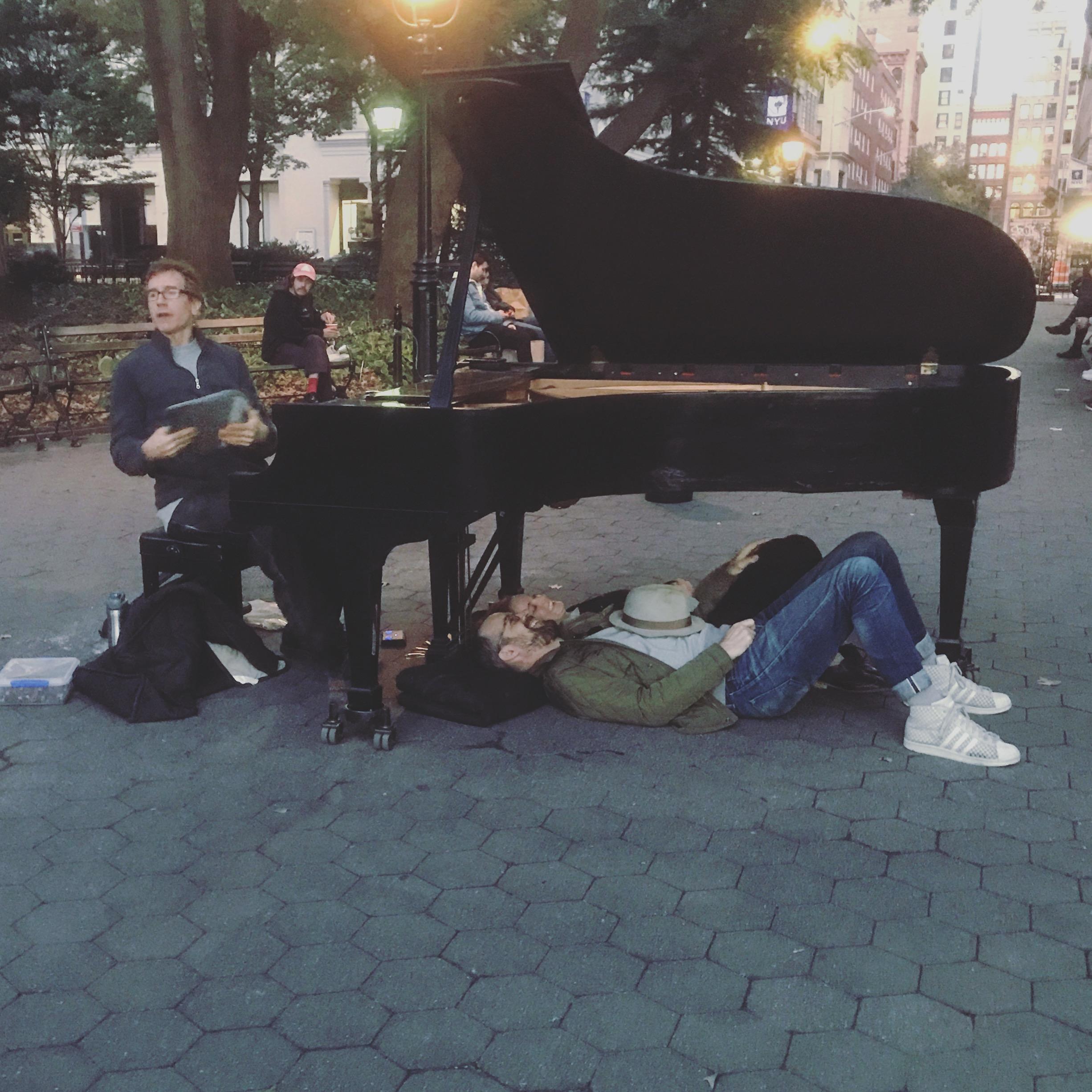 Listening to music under the piano in Washington Square Park, New York