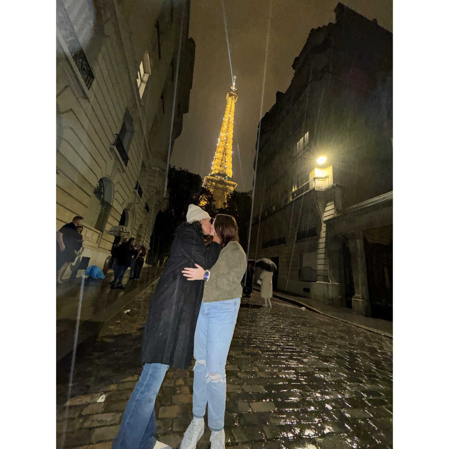 Caught in the rain, in front of the Eiffel Tower, our love felt even more magical.