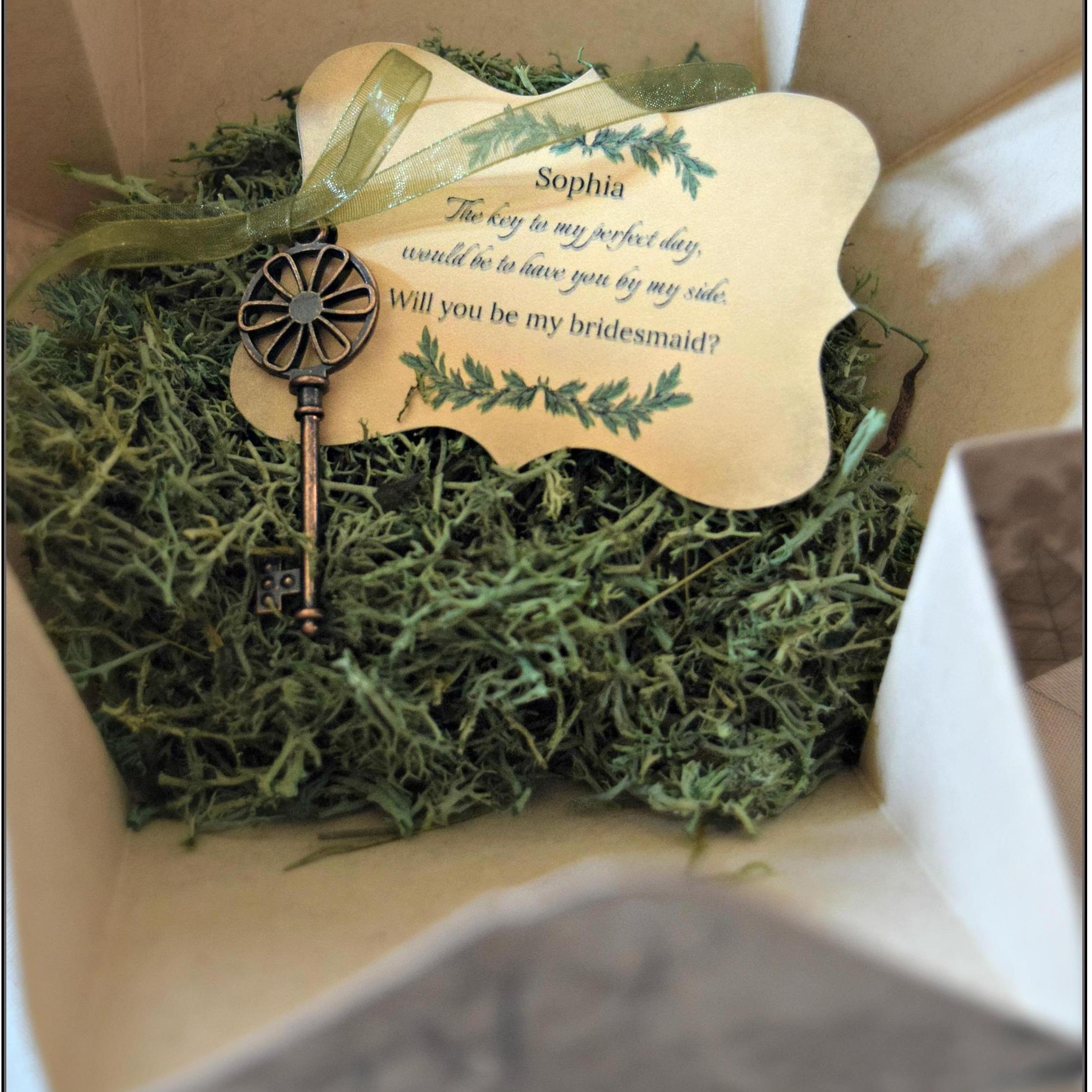 The key and bridesmaid gift invitation were presented on a bed of reindeer moss.