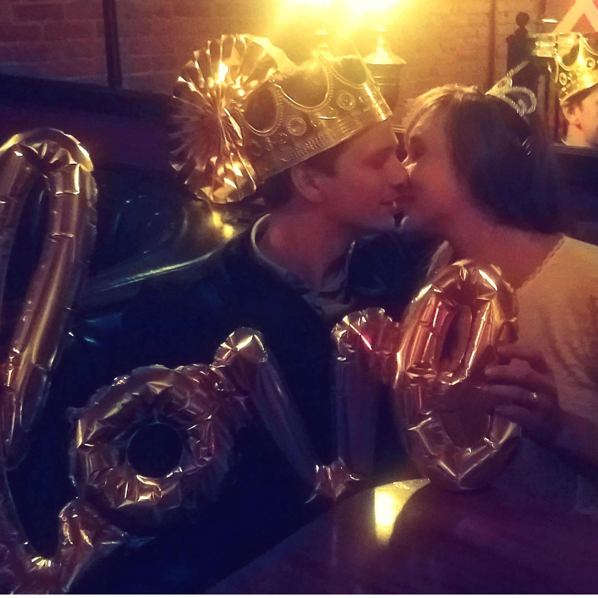 Sneaking a kiss in engagement party bliss.