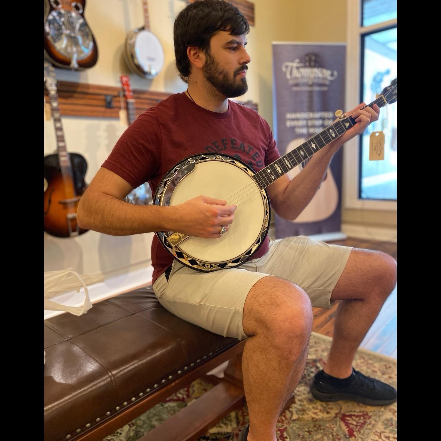 Trying out guitars and banjos at Lowe Vintage Instruments in downtown Burlington, North Carolina while we were apartment hunting, April 2023