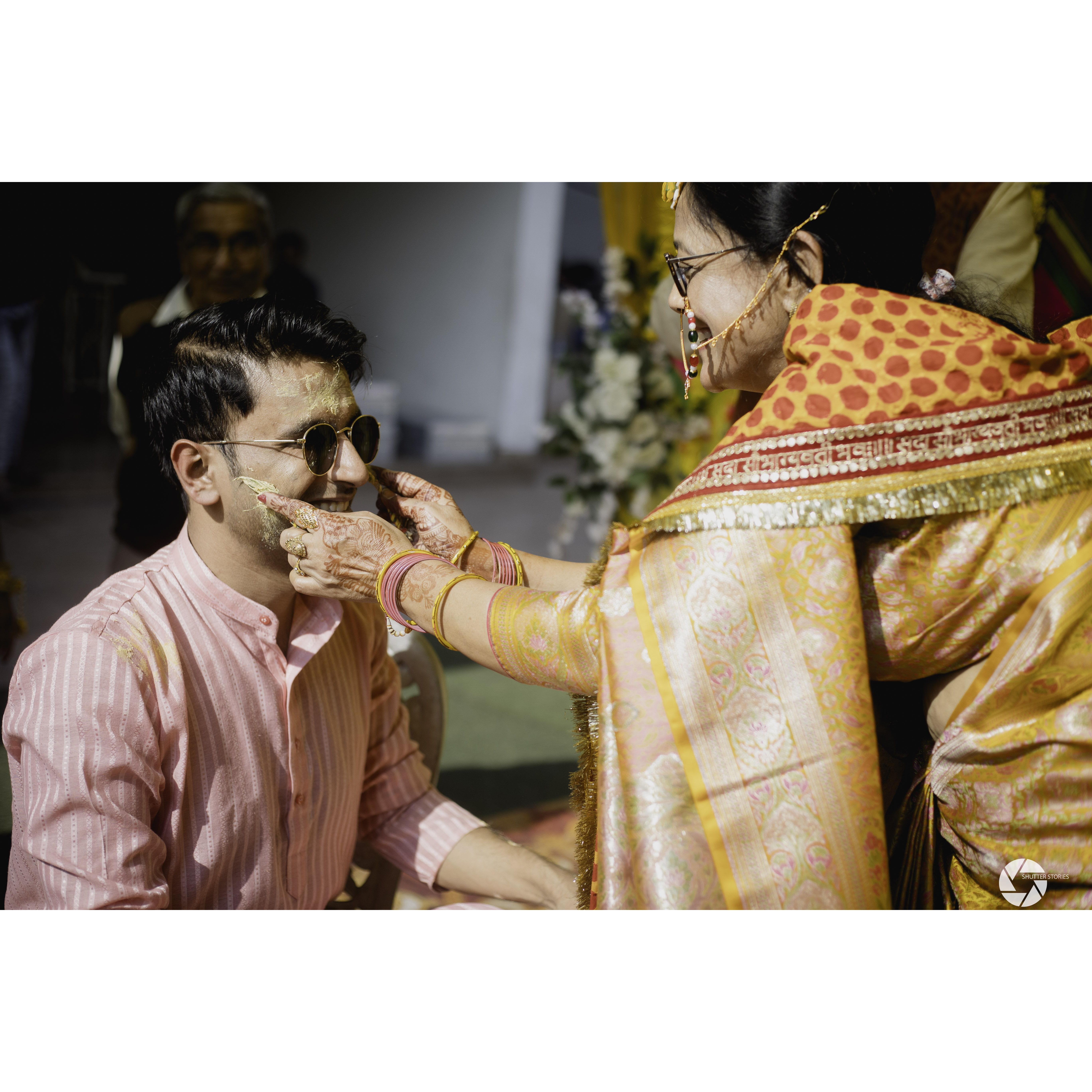 The "Haldi" ceremony. The family applies a turmeric based paste on the bride and groom to "beautify" them for the big day