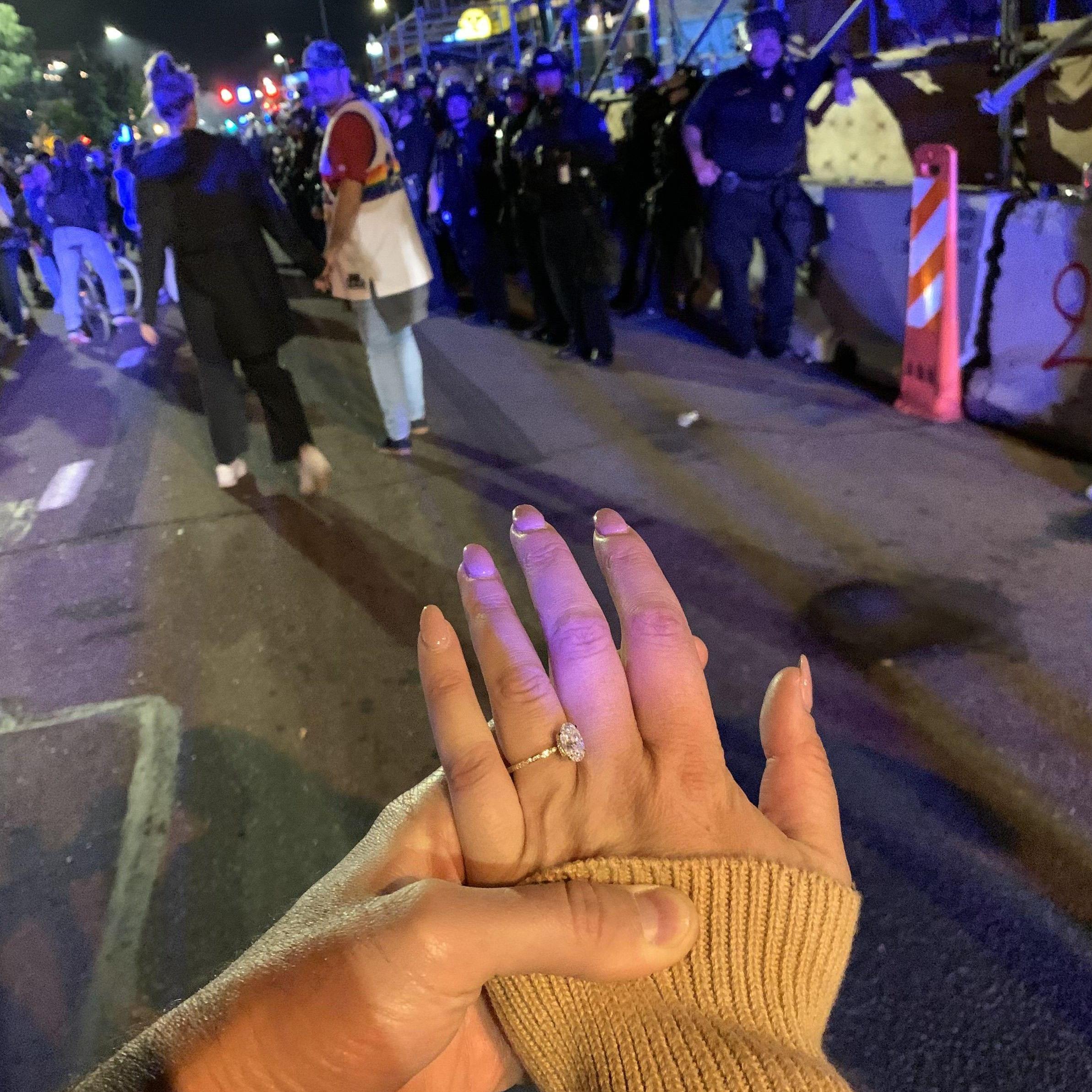 Kaila showing off her ring in front of the riot police after Nuggets won the championship.
