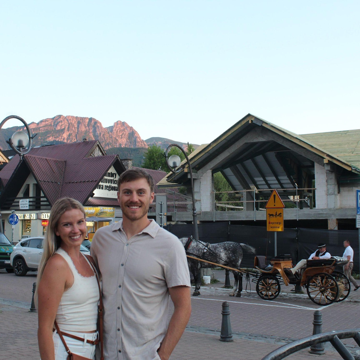 One of our most memorable trips was to Zakopane, Poland. This is us standing in downtown Zakopane with a Góral Horse-drawn Carriage and Giewont Mountain in the background. (2025)