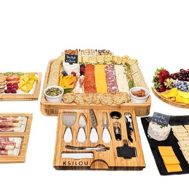 KSILOU charcutrie boards,Bamboo cheese board set includes a side cheese tray, a round fruit tray, ceramic bowls, three serving plates, a knife set, forks, and a wine opener