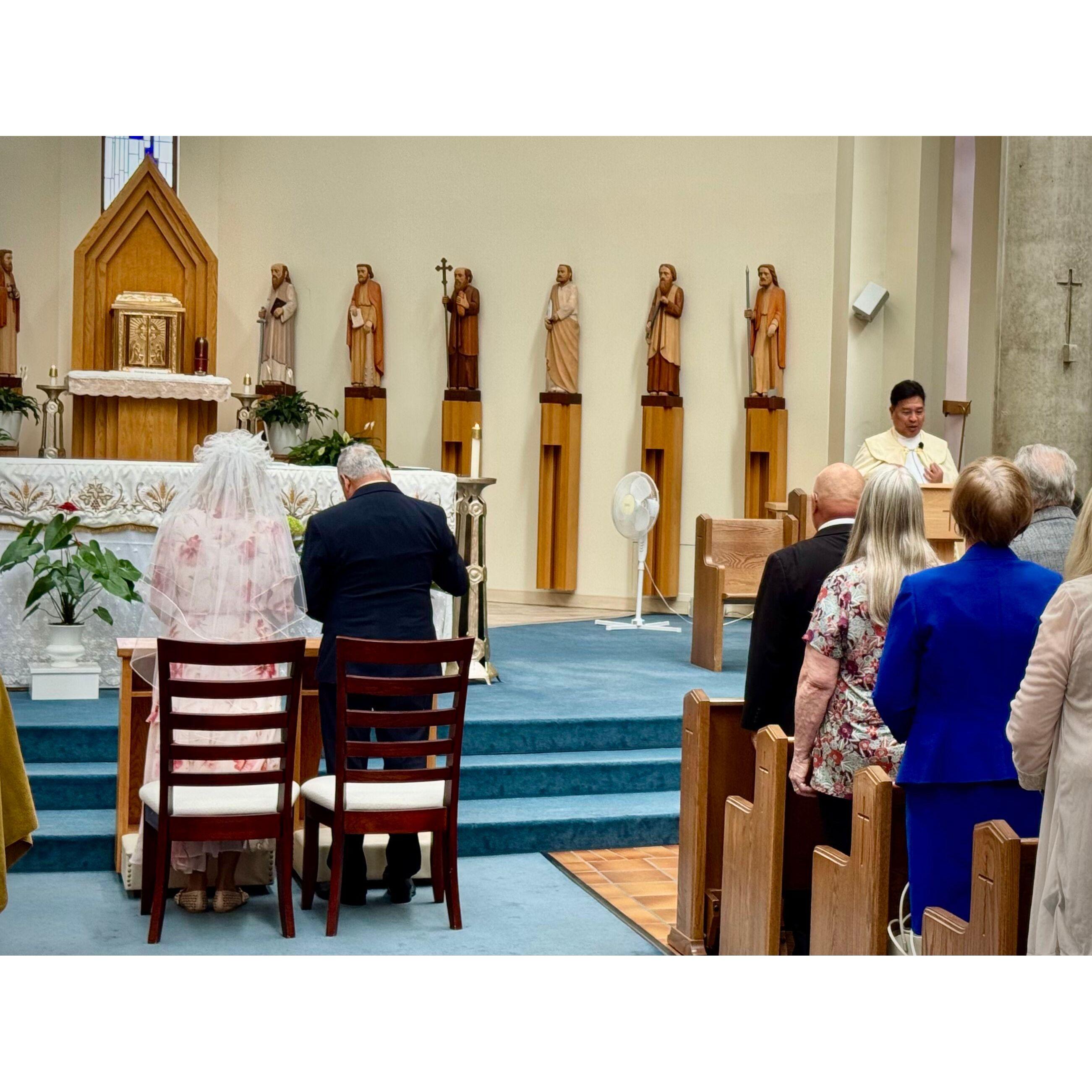 The bride and groom are ready at the front of the church.
