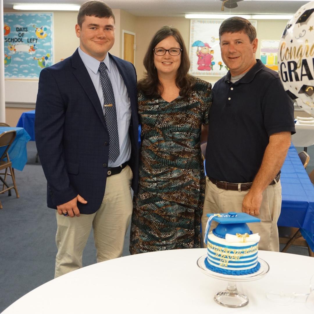 Joseph and his parents and the cake Megan made for his graduation!