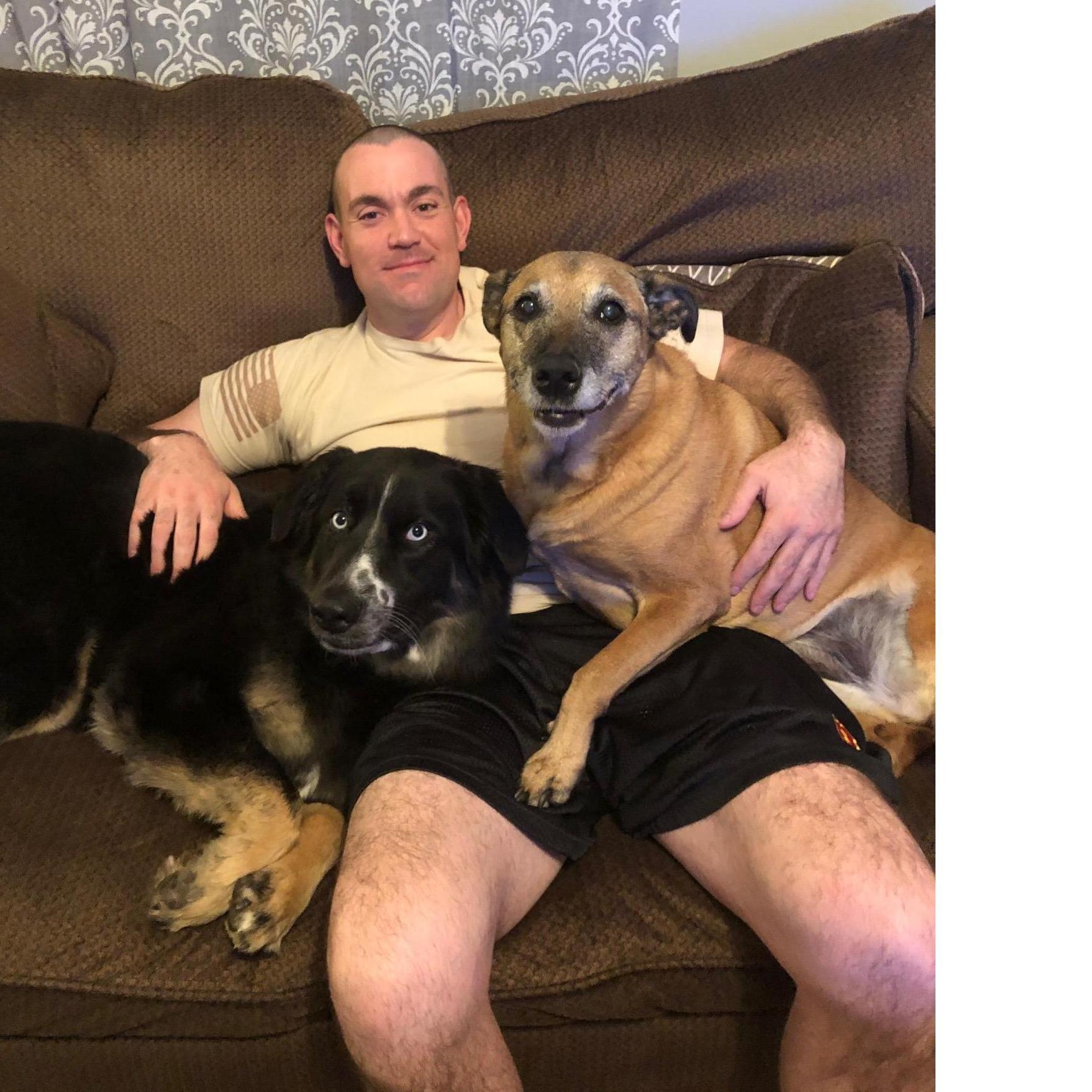 Brad relaxing with our two spoiled rotten doggos.