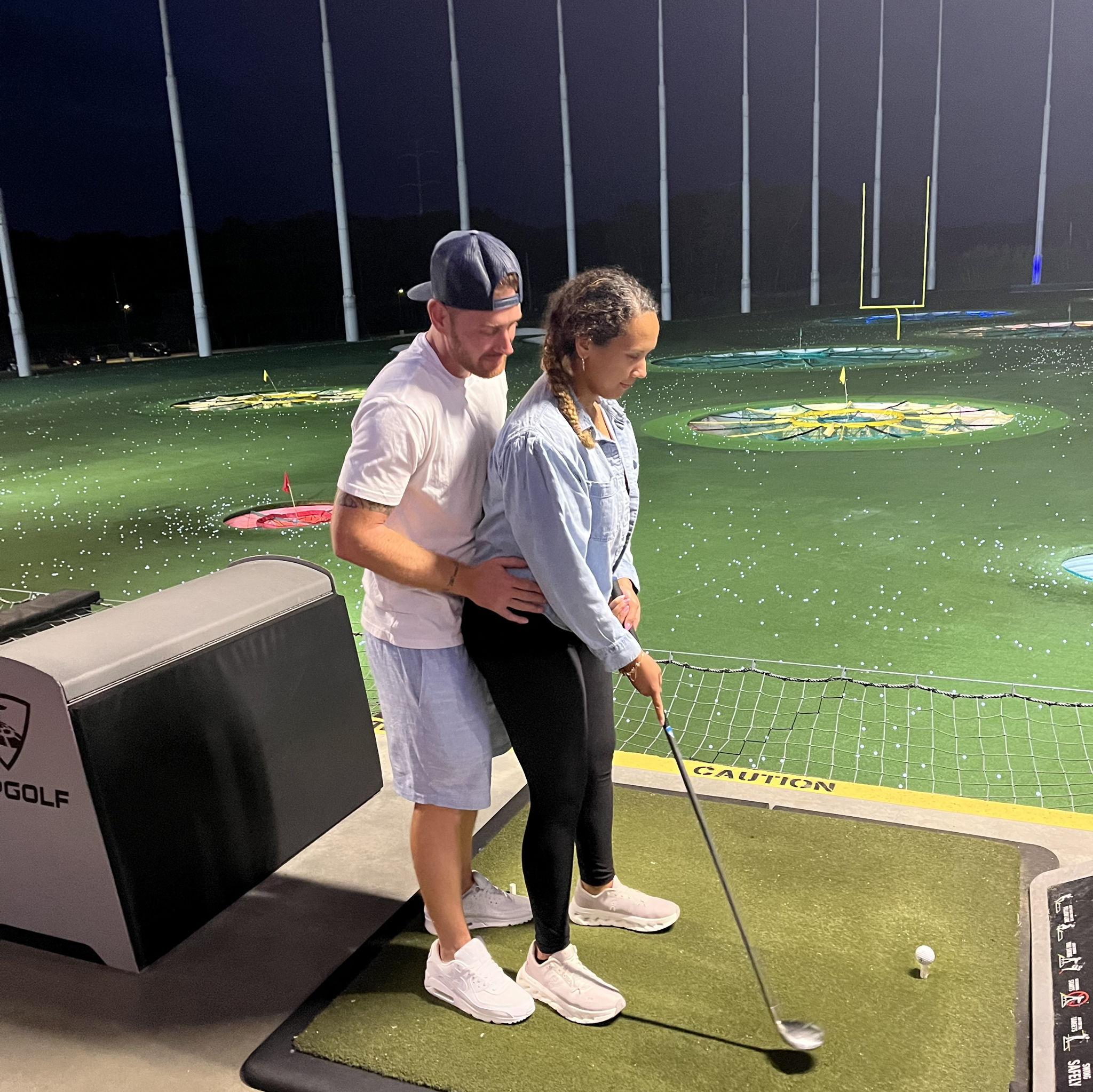 Jereme attempting to give Regina Leilani golfing lessons