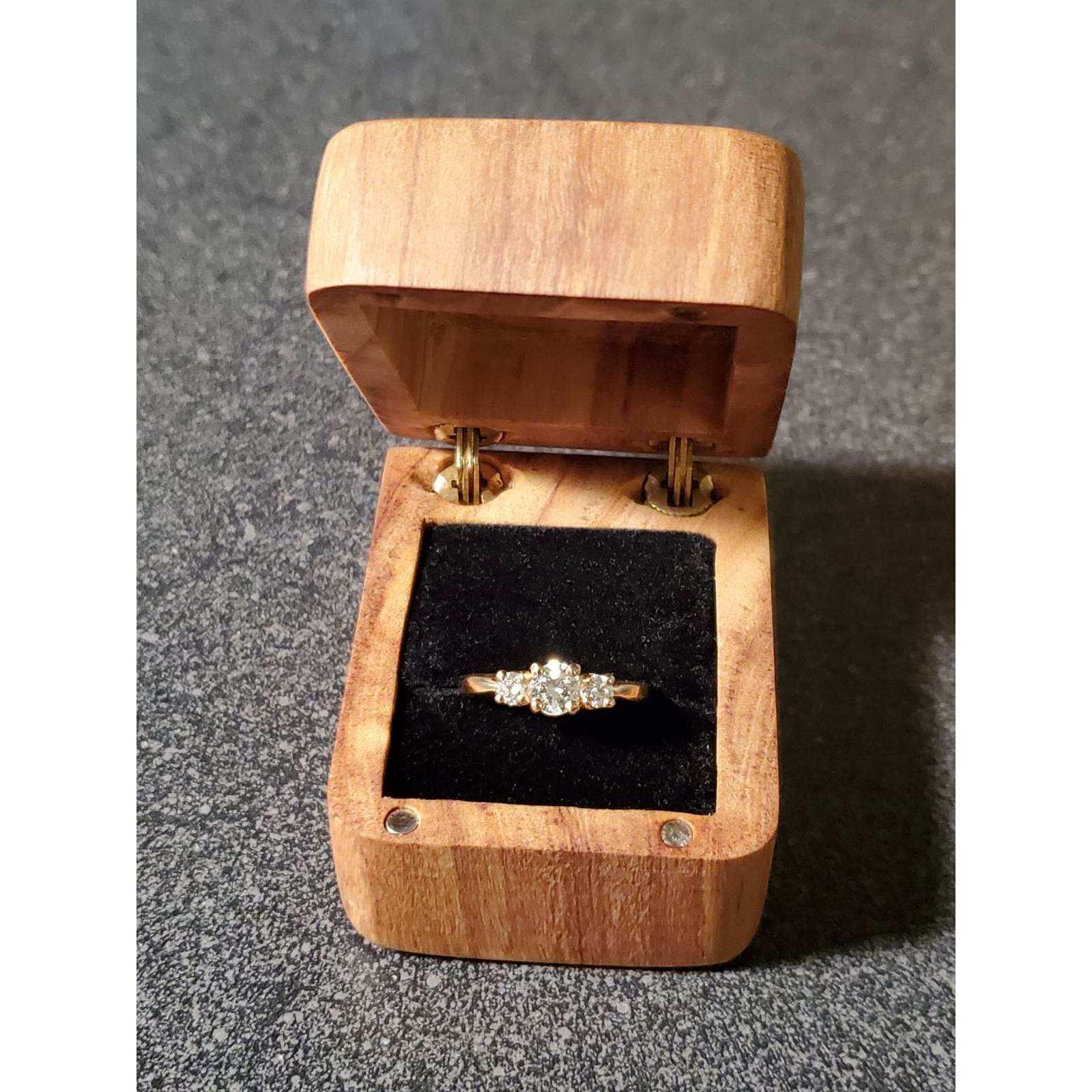 James hand-made the box out of Olive wood without power tools, in honor of their trip to Barcelona where he realized he'd want to marry her. He reset Kylie's great-grandmother's diamond in a new band.
