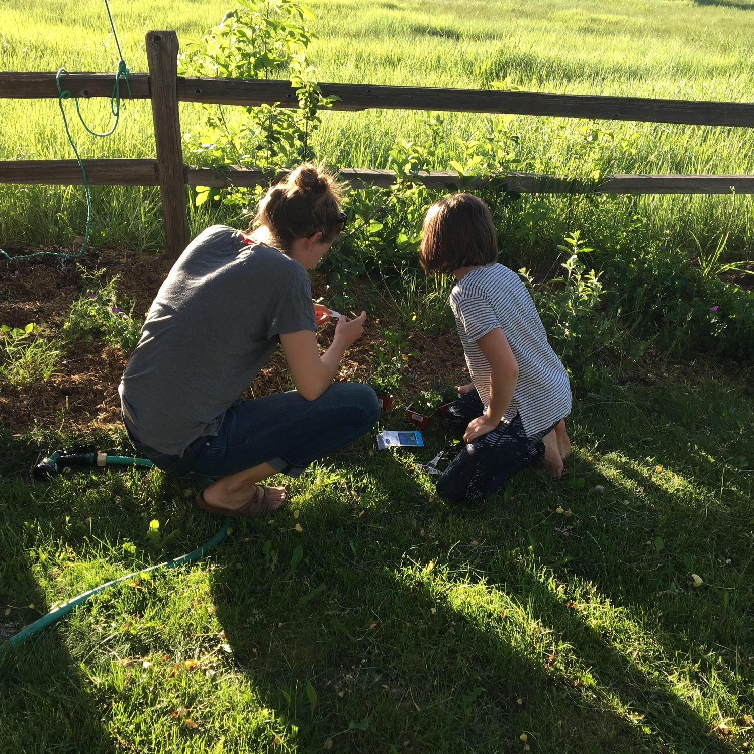 Marcy and Emi adding wild flowers to Mom's/Janet's garden
