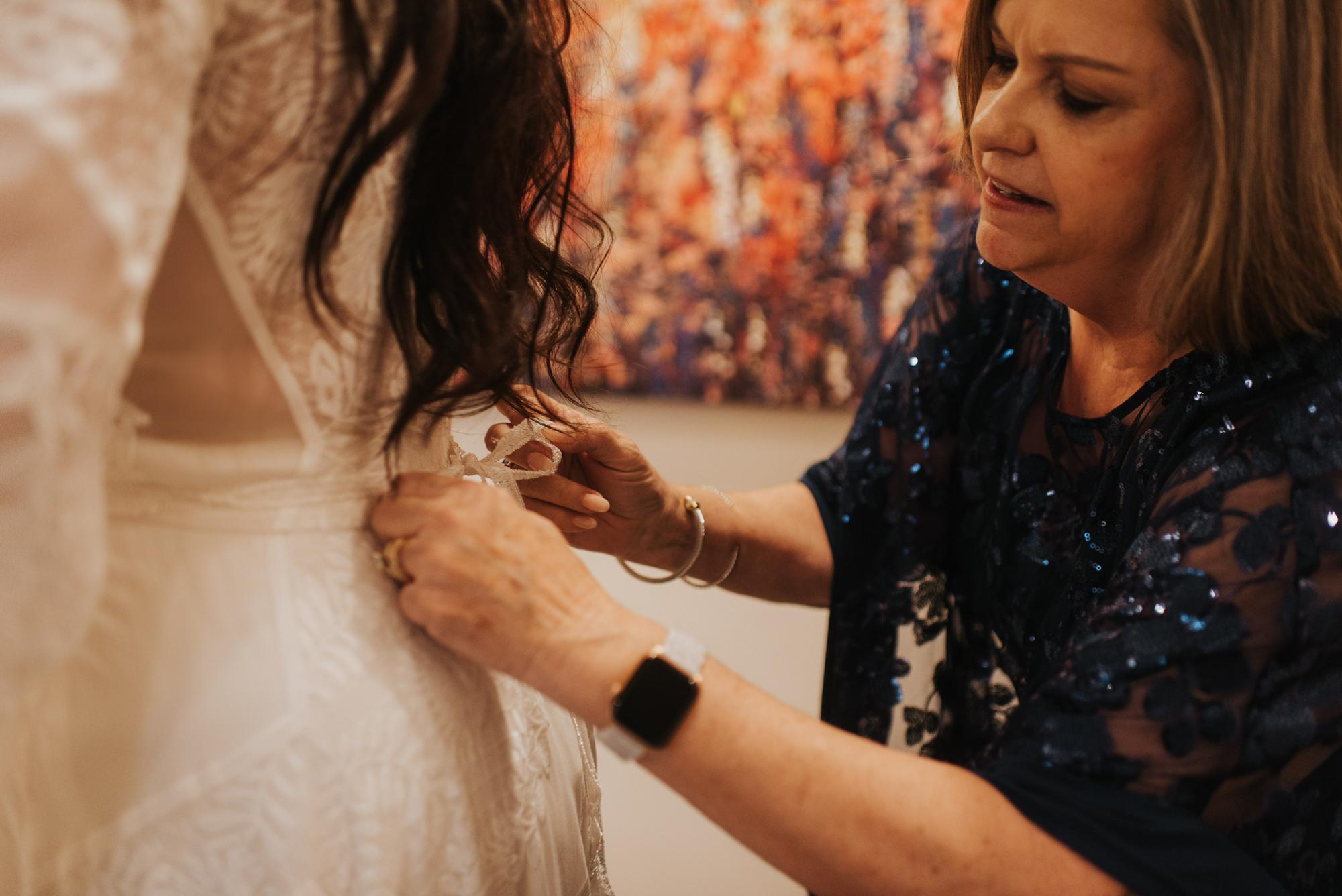 Helping the bride tie her dress