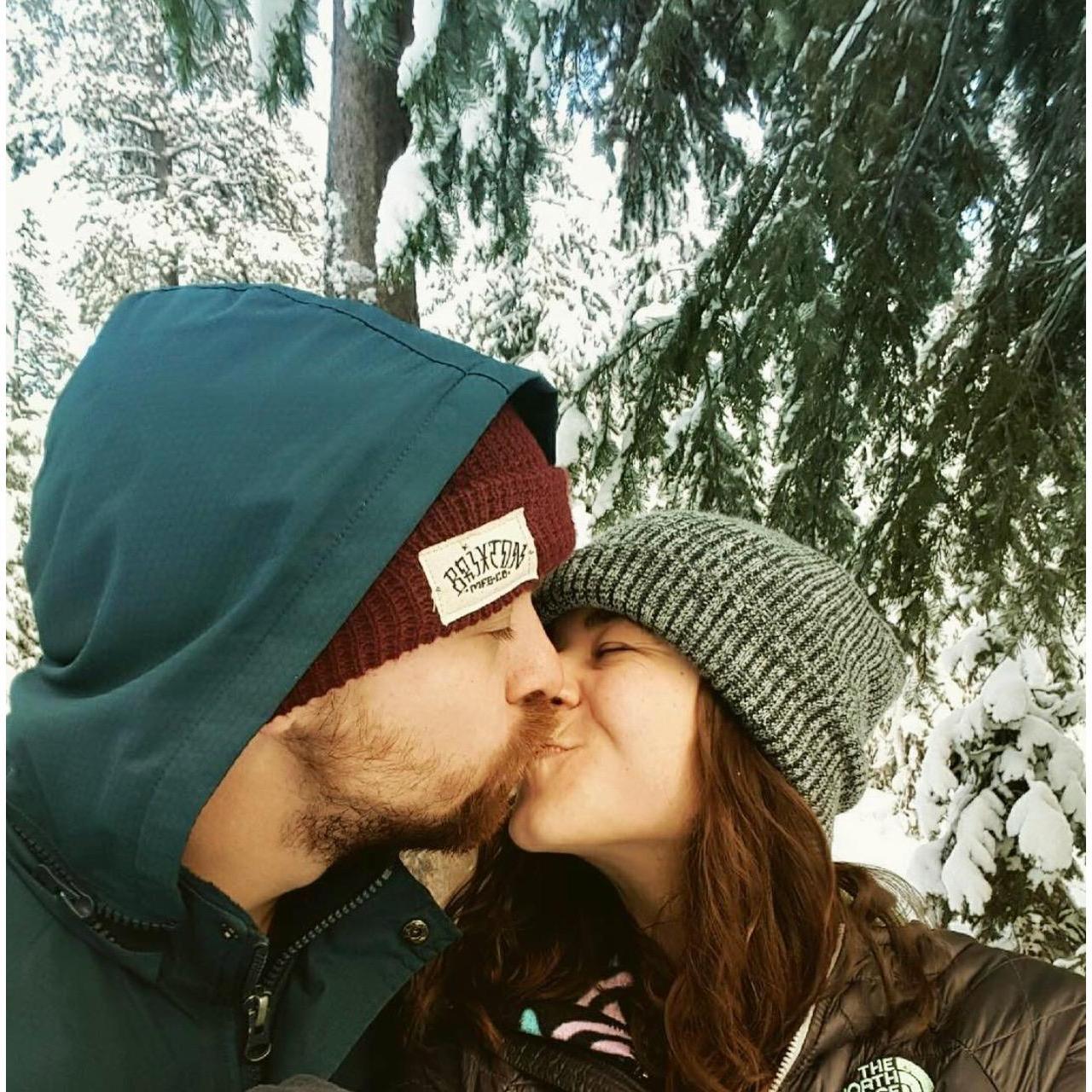 Kiss in the woods of Oregon while snowshoeing.