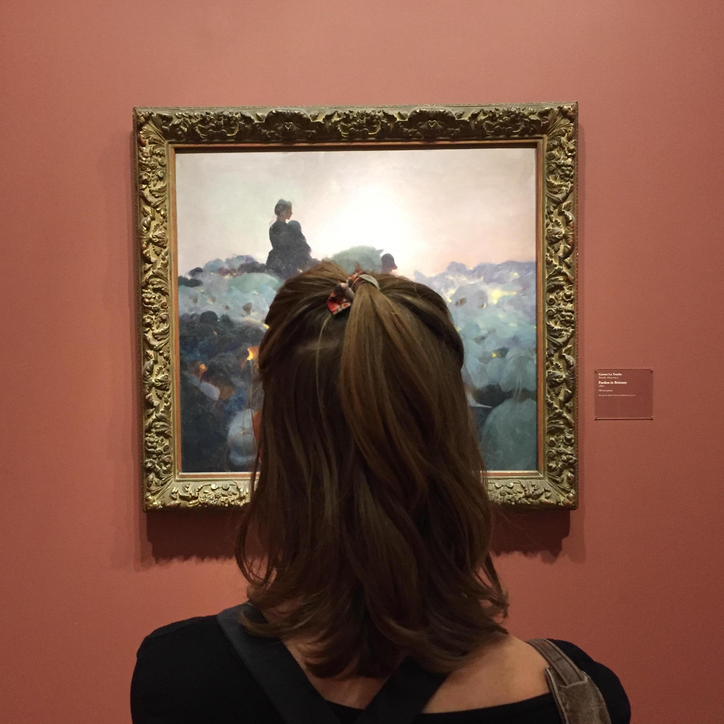 Katie took John to the Art Institute of Chicago. She's looking at: Pardon in Brittany by Gaston La Touche