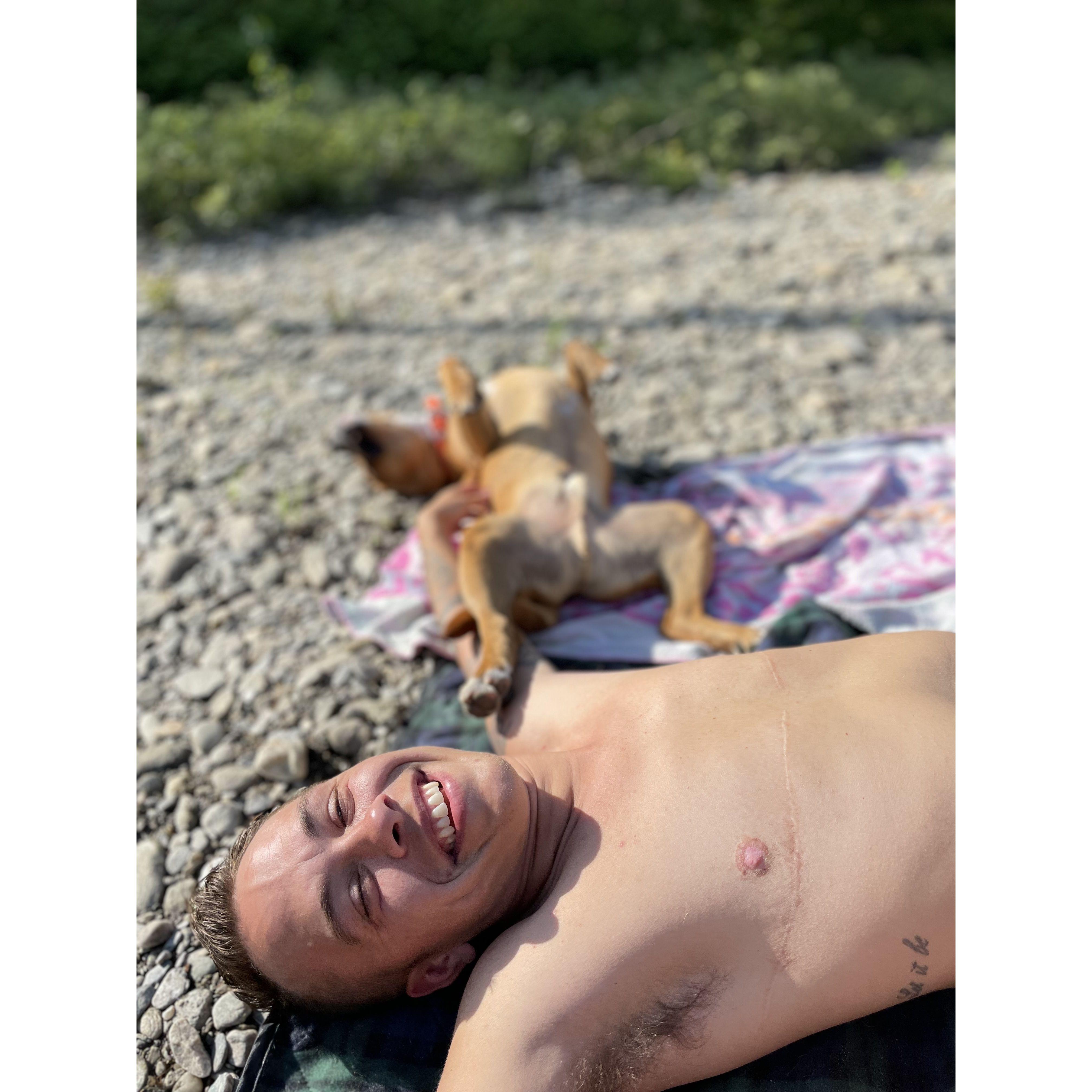 Hugo and Luke lounging by a river in Warren