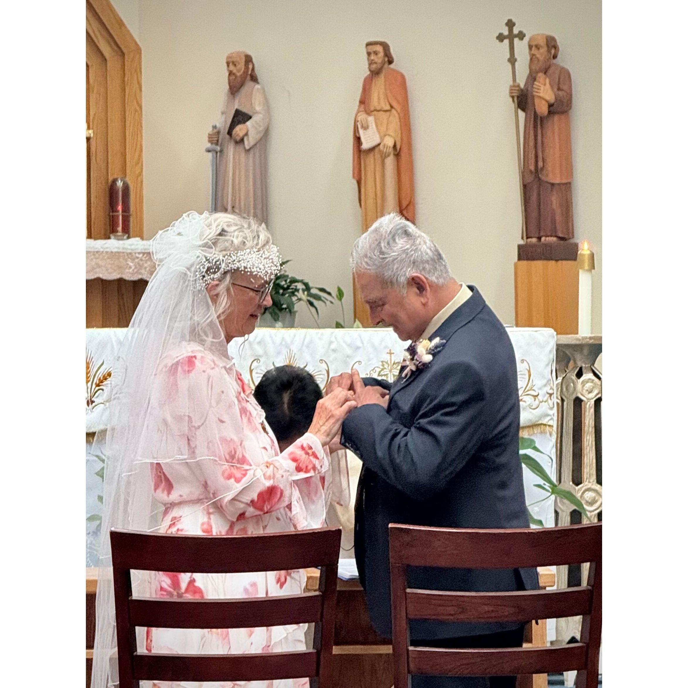 Leonard places the wedding ring on Anita's finger.