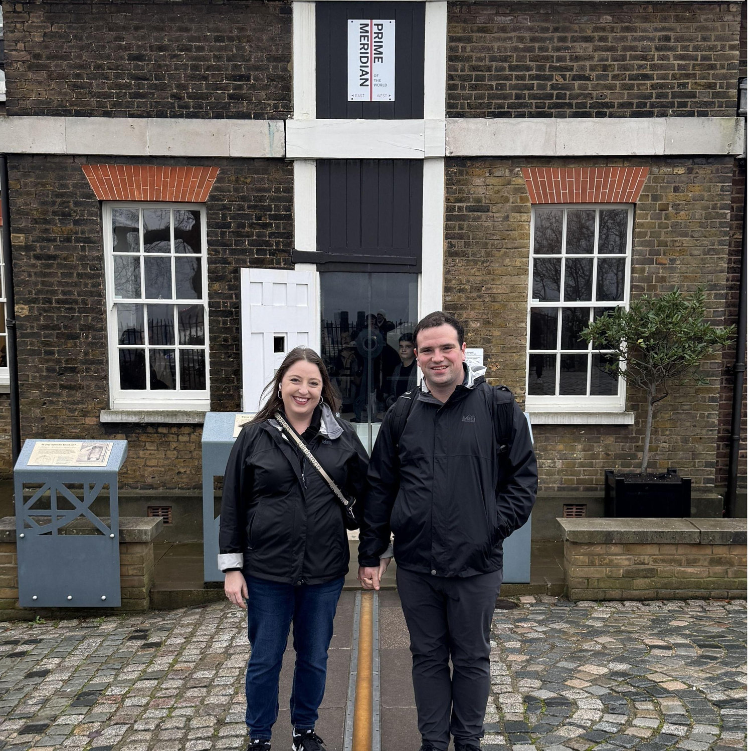 Standing on in opposite hemispheres over the prime meridian.