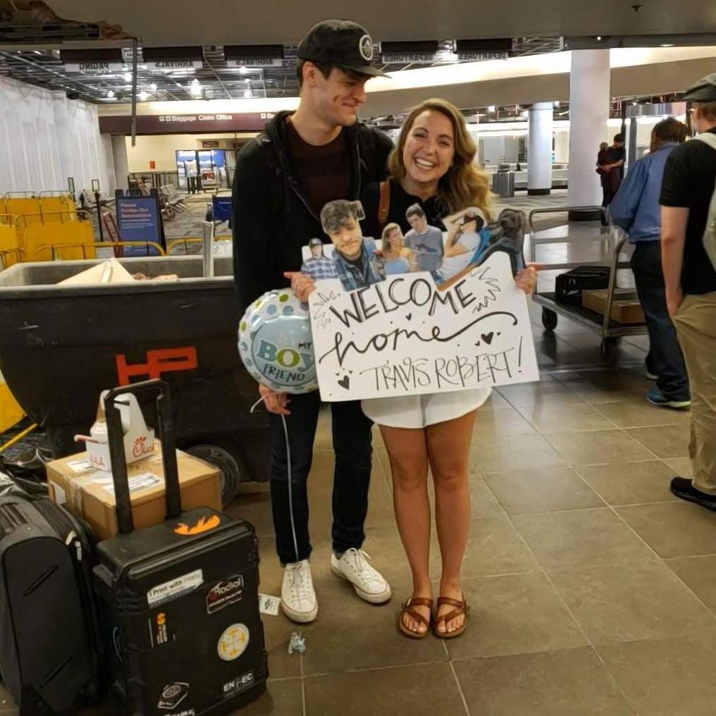 When your boyfriend is traveling...you show up at the airport with a sign.