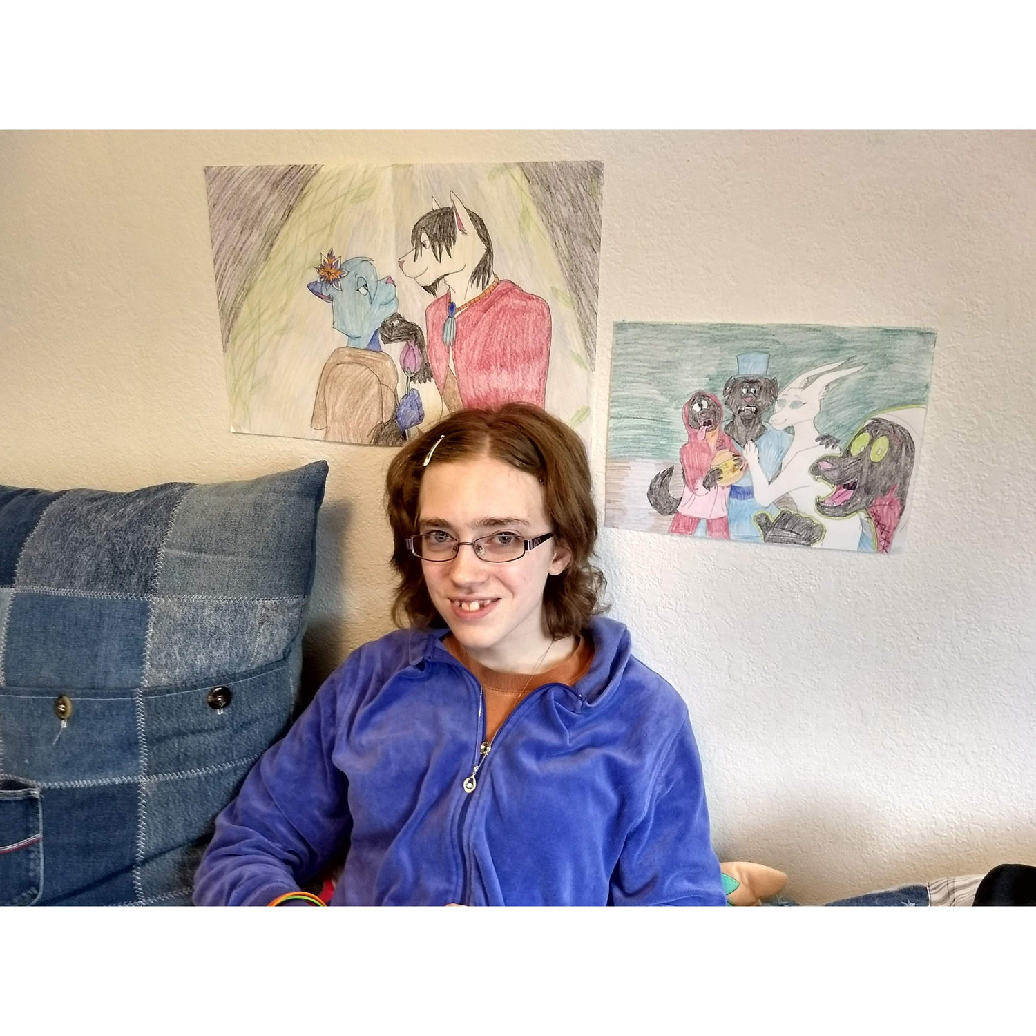 Sean sent Syd a necklace for her birthday. She's posing under a cartoon she made of her and Sean as cartoon characters.