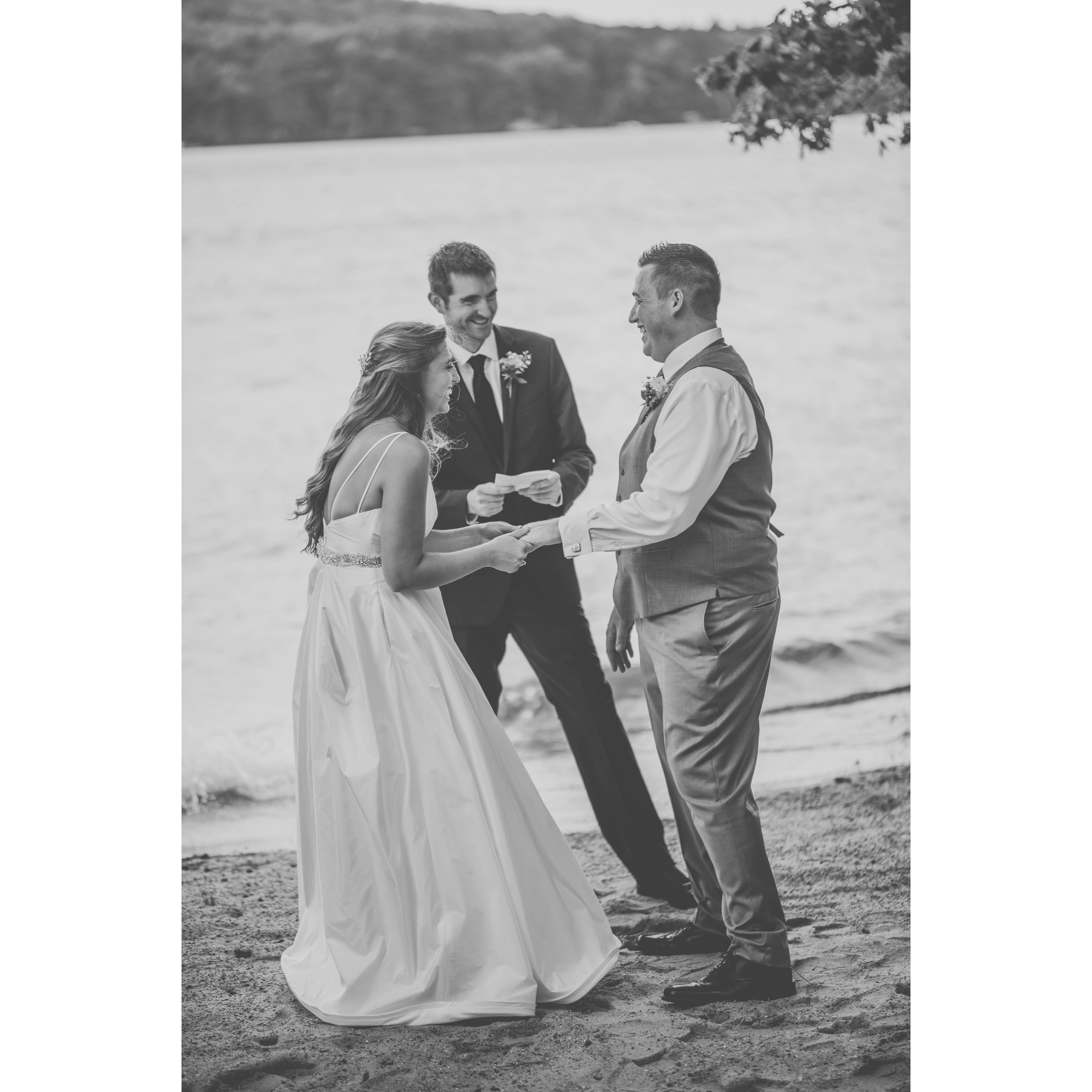 The bride and groom having a great time saying their vows with assistance of their officiant/one of the best men.