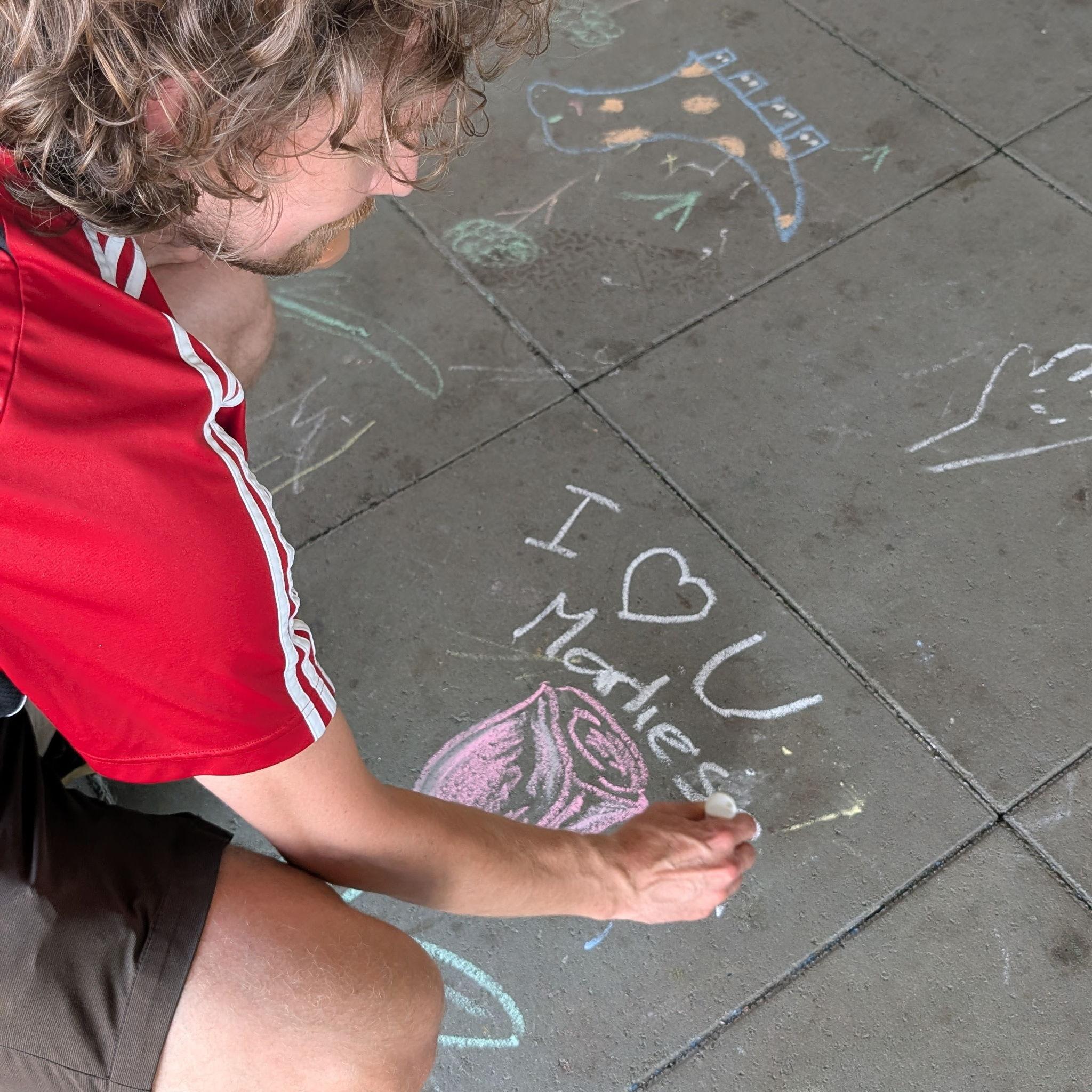 Taylor drawing Marliese romantic art pieces at the local Farmer's Market
