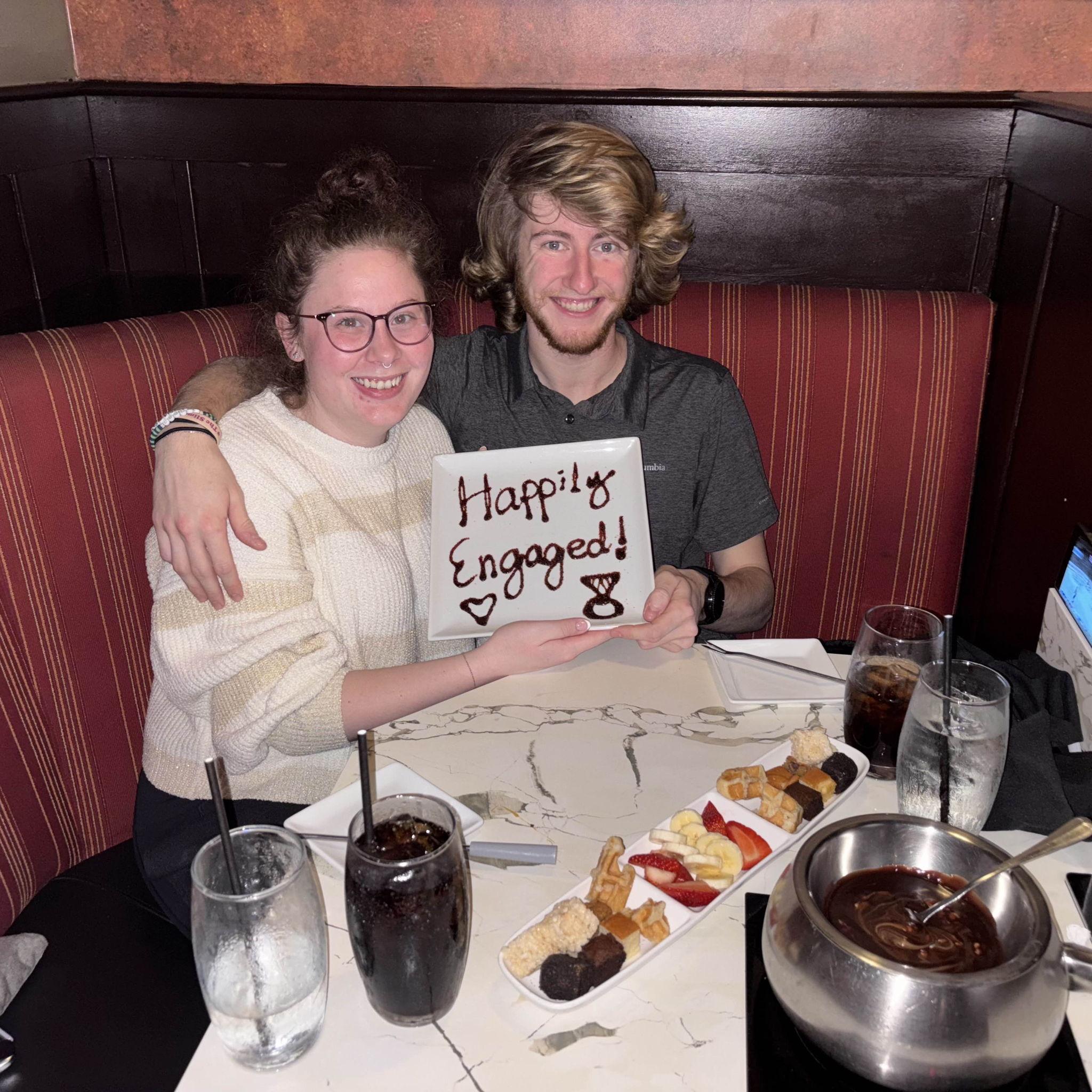 At The Melting Pot to celebrate our engagement, please note the Blues game in overtime on Cooper's phone in the corner. We watch the game always, no matter the occasion.