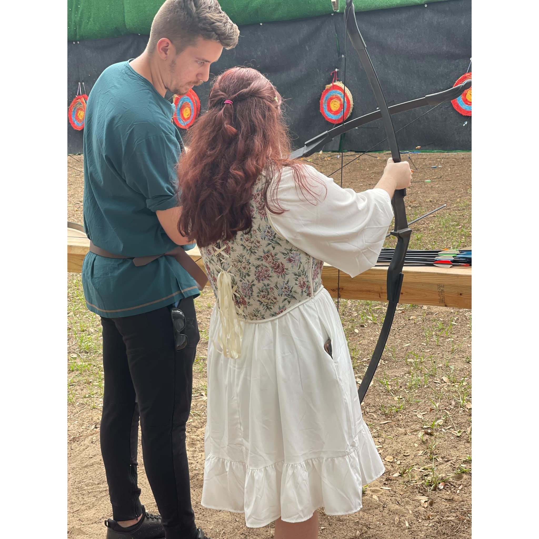 Eric reminding Kaley how to hold a bow.