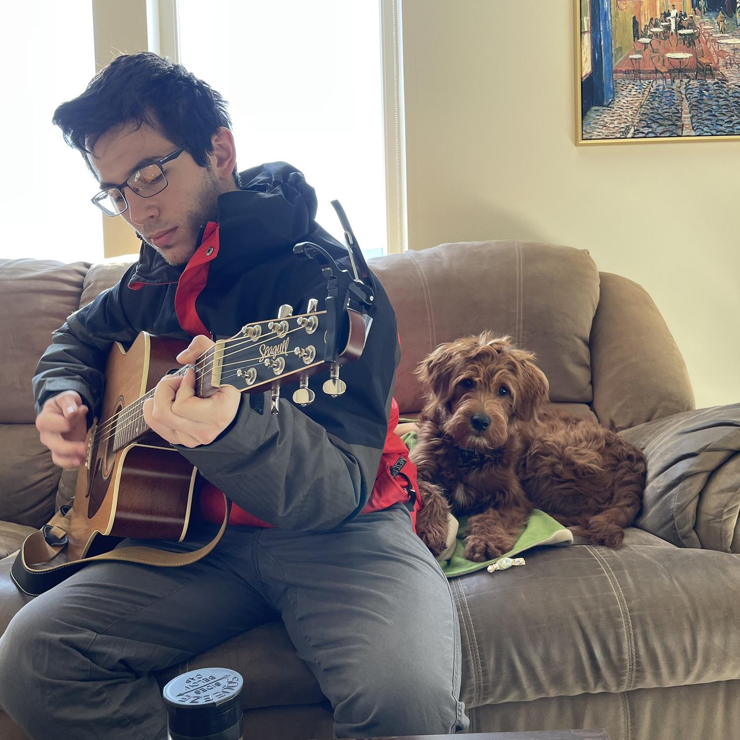 Velma listening to Mitchell play the guitar in his MKE apartment.