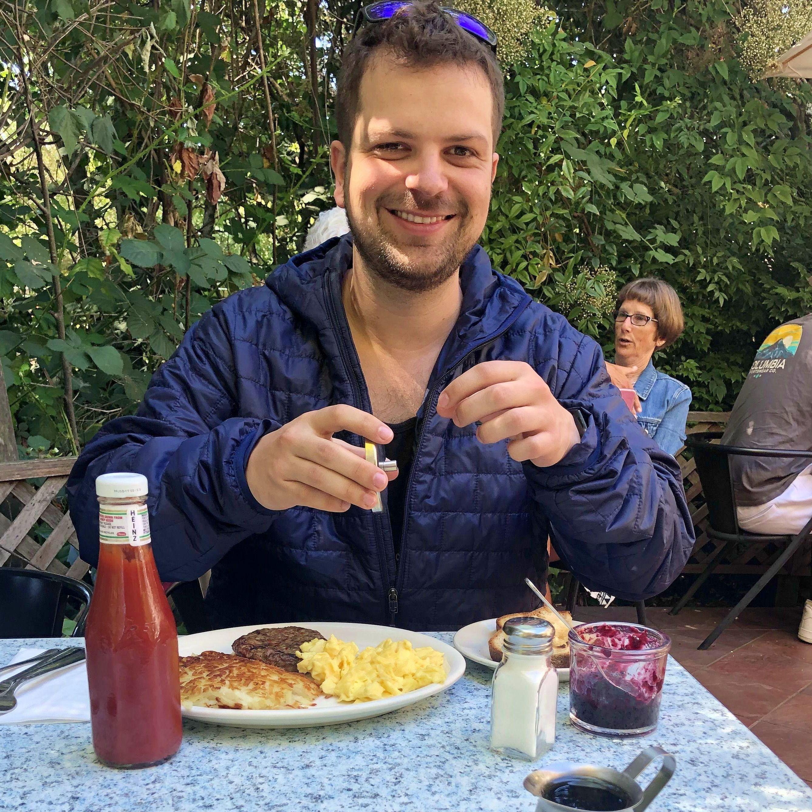 Stephanie enjoys taking pictures of Kevin eating breakfast.
