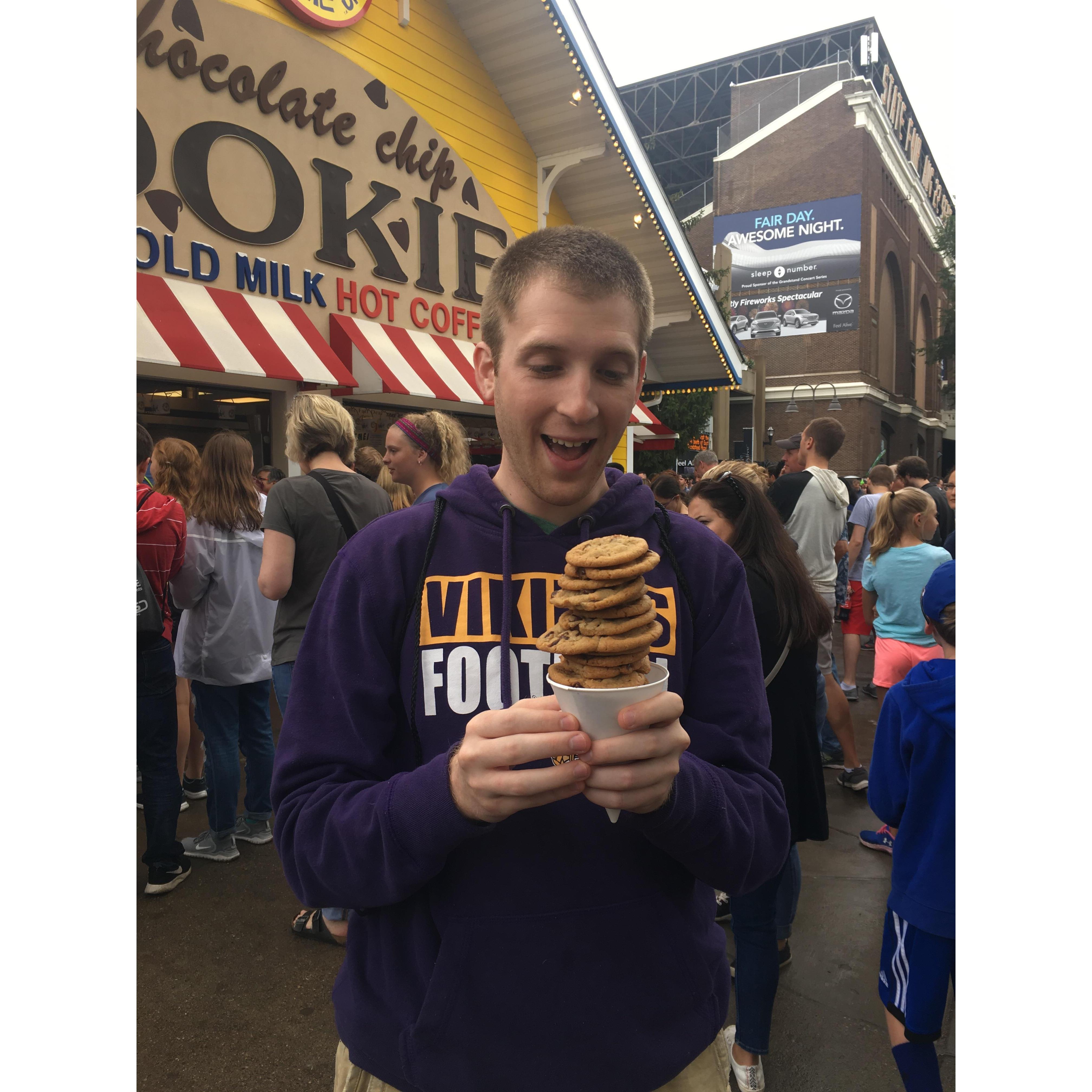After months of long distance, Andrew moved to Mpls. in Dec. 2018. By  summer, he was a true Minnesotan! Here he is enjoying the Minnesota State Fair with his vikings sweatshirt and famous cookies!