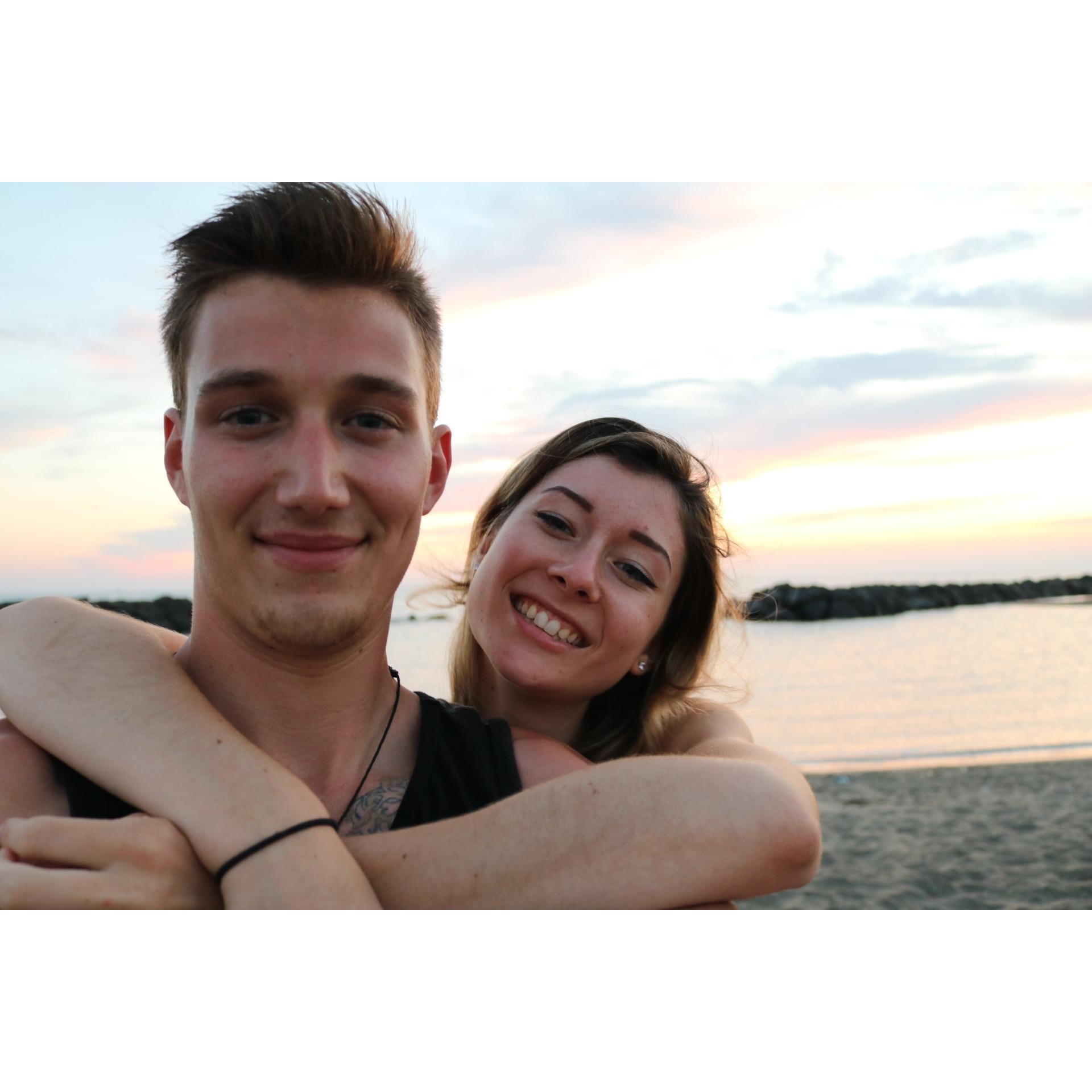 A sunset picnic of salami, mozzarella and bread and beers on the beach in Fiumicino Italy