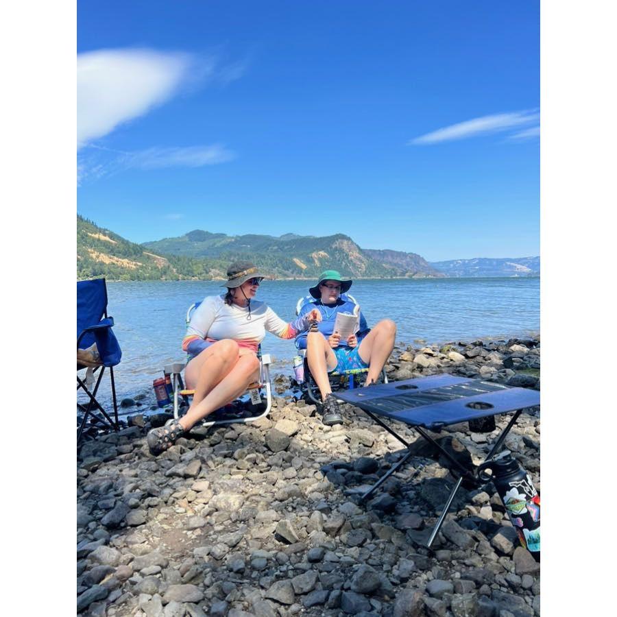 Kylie is stacking rocks on Cyn's leg while she reads...obviously