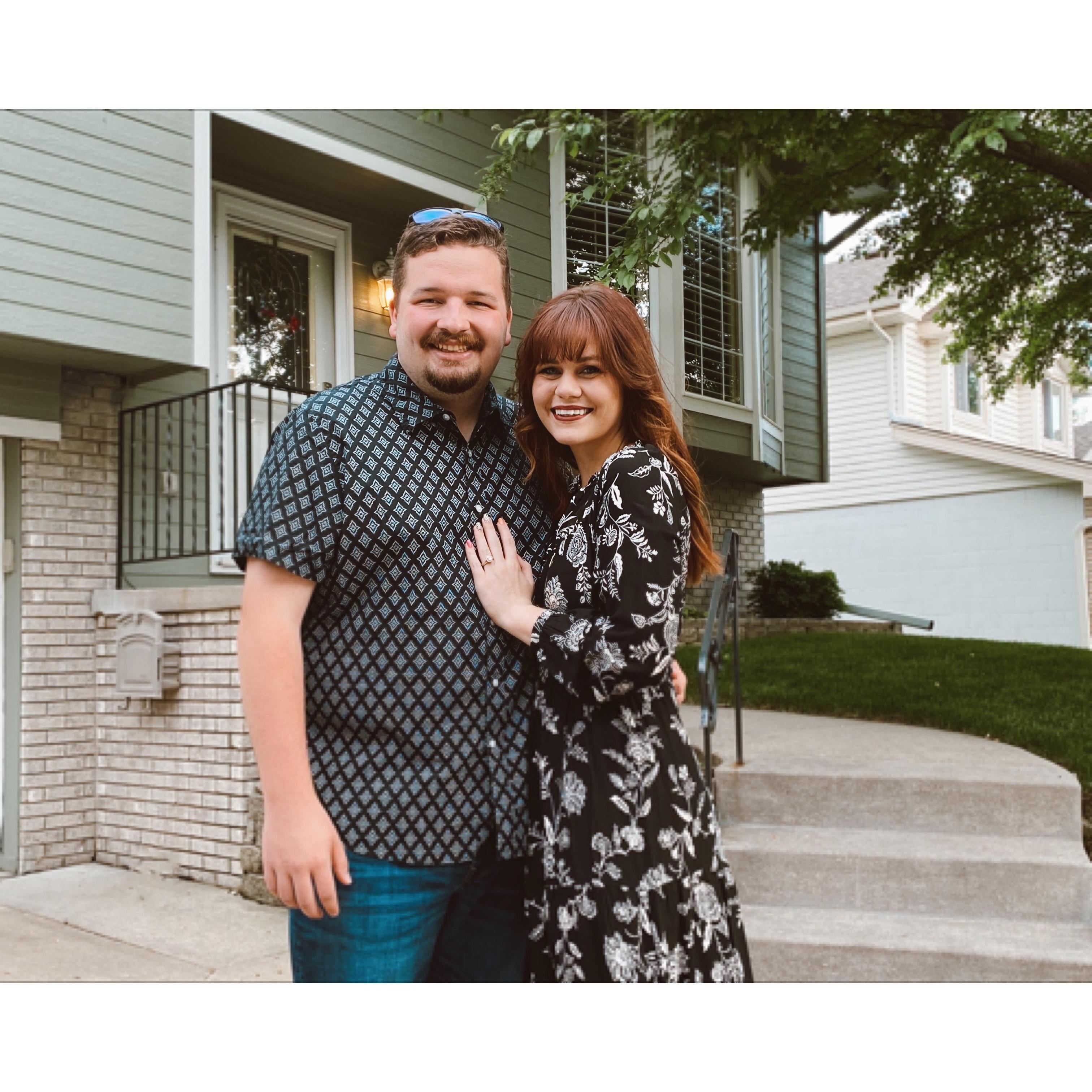Happily Engaged in front of their home