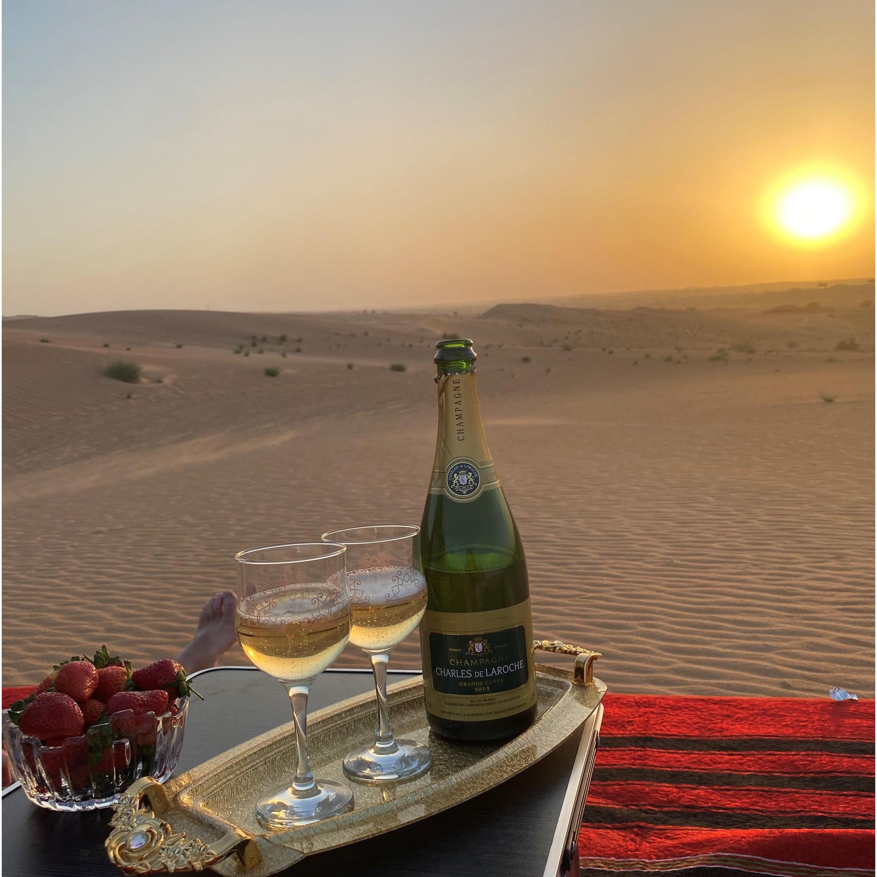Proposal celebration with champagne in the desert overlooking the sunset.
