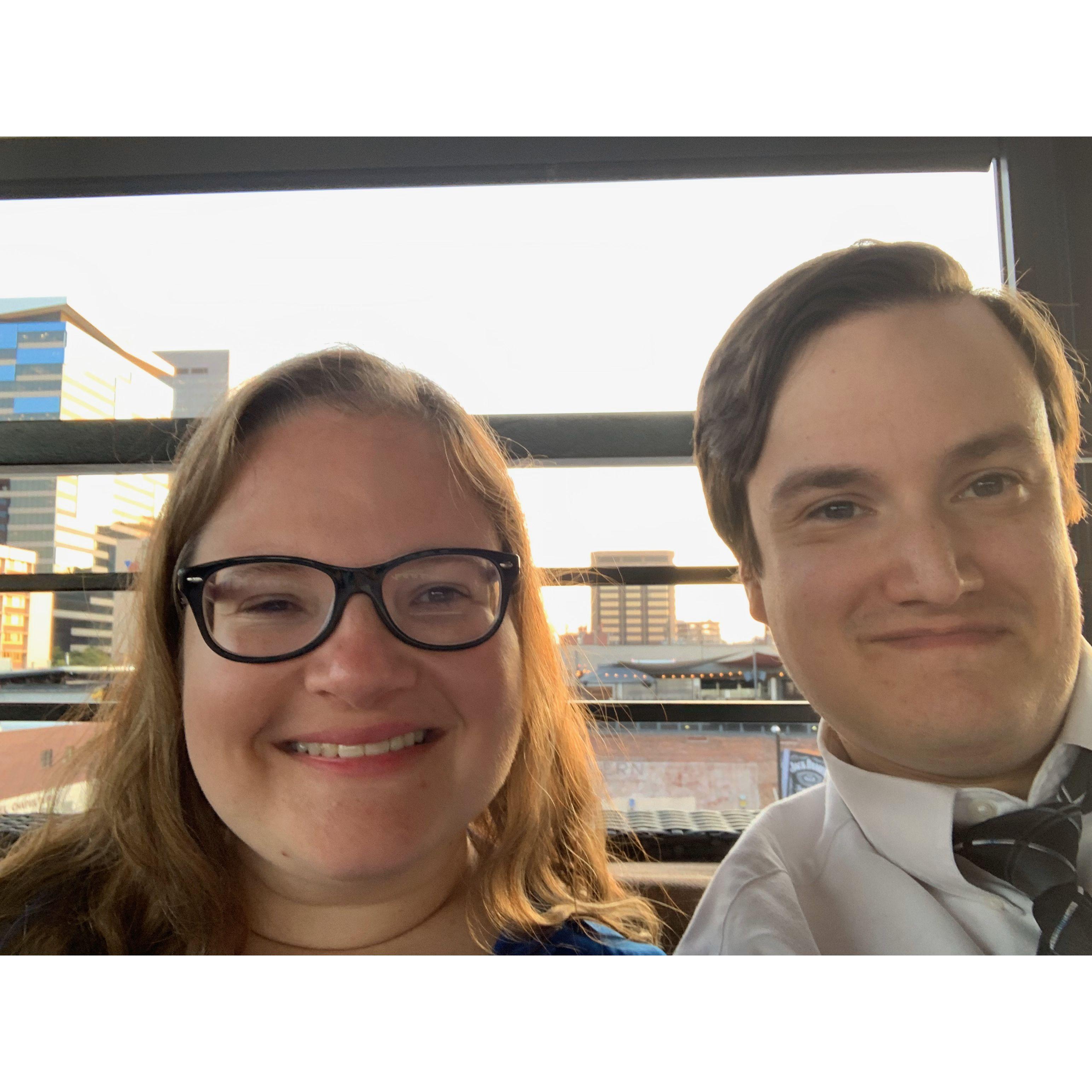 A selfie with the setting sky in Denver, CO behind them .