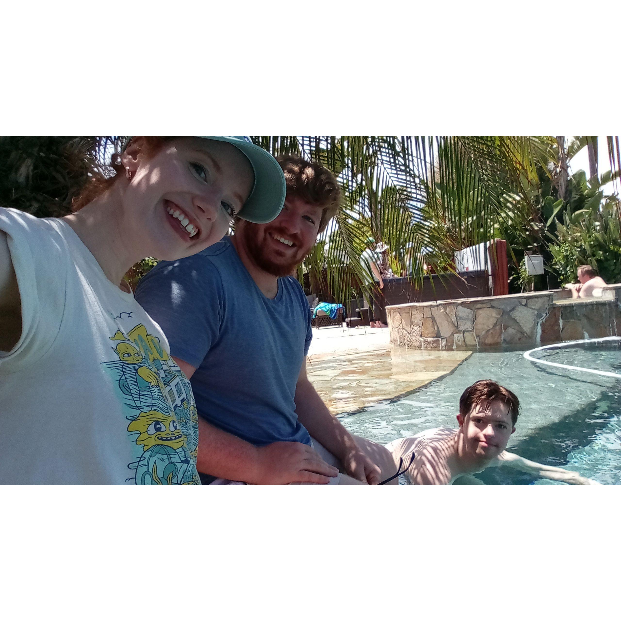 Amy, William, and Martin lounge by the pool in San Diego.