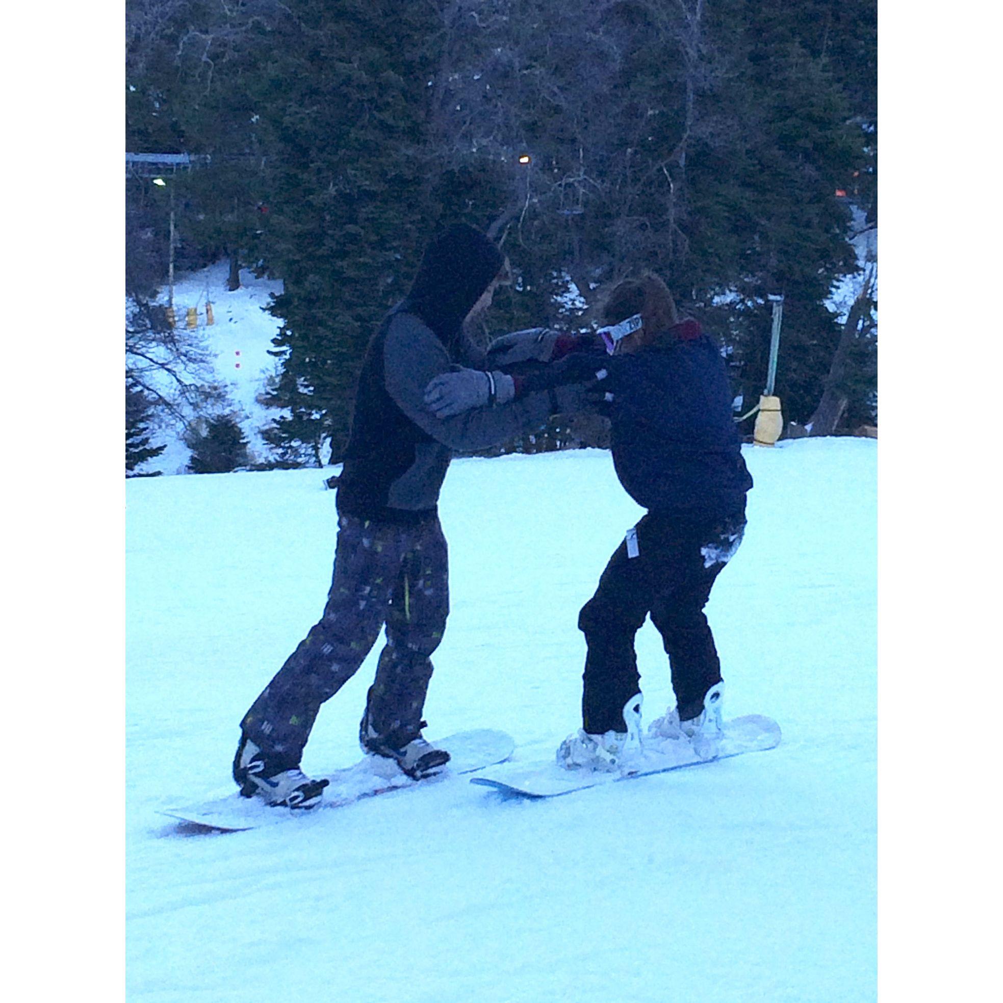 Brady teaching Sofia how to snowboard