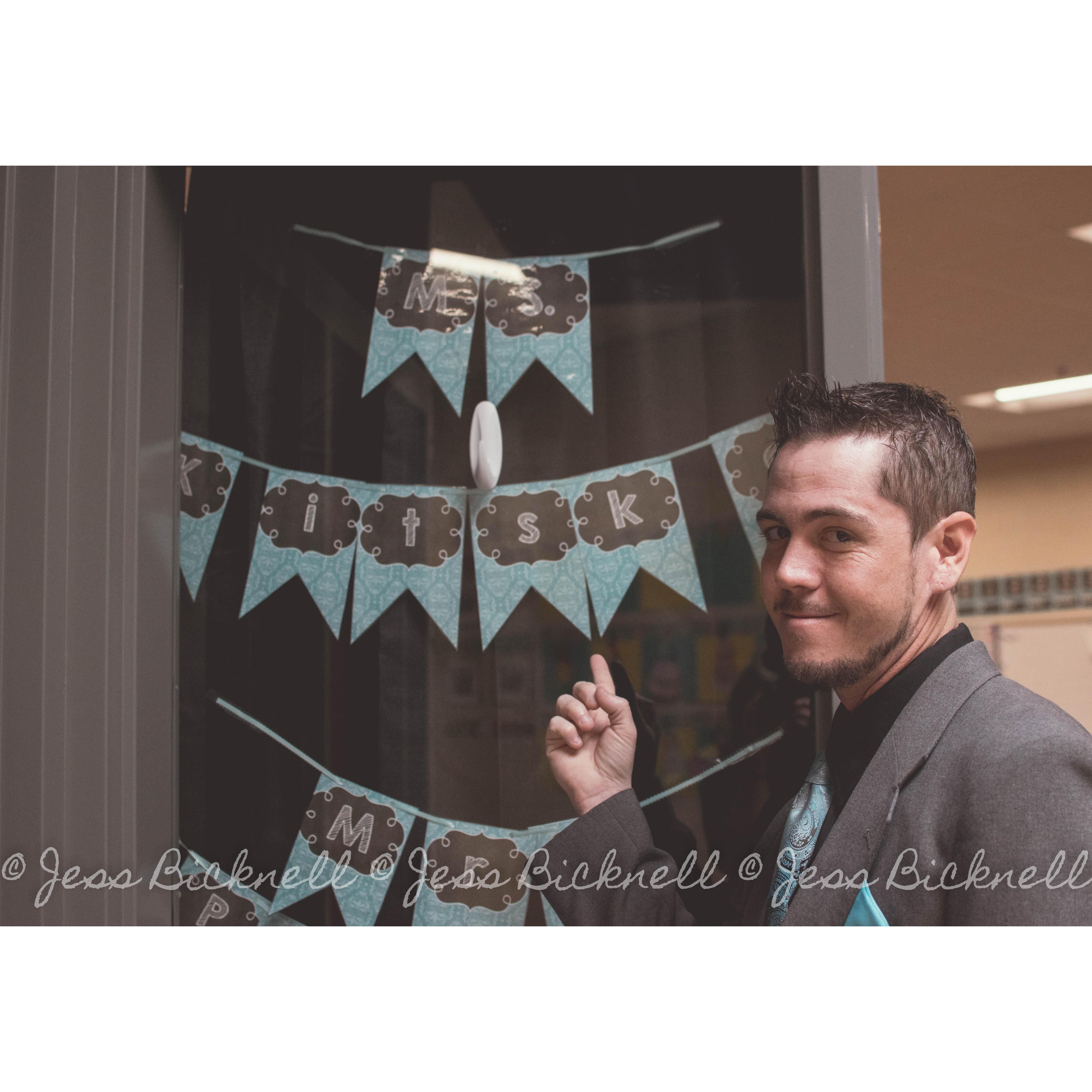 Kevin, waiting outside the classroom for a moment, while we set up the proposal inside. This is him saying her last name would soon change to his!