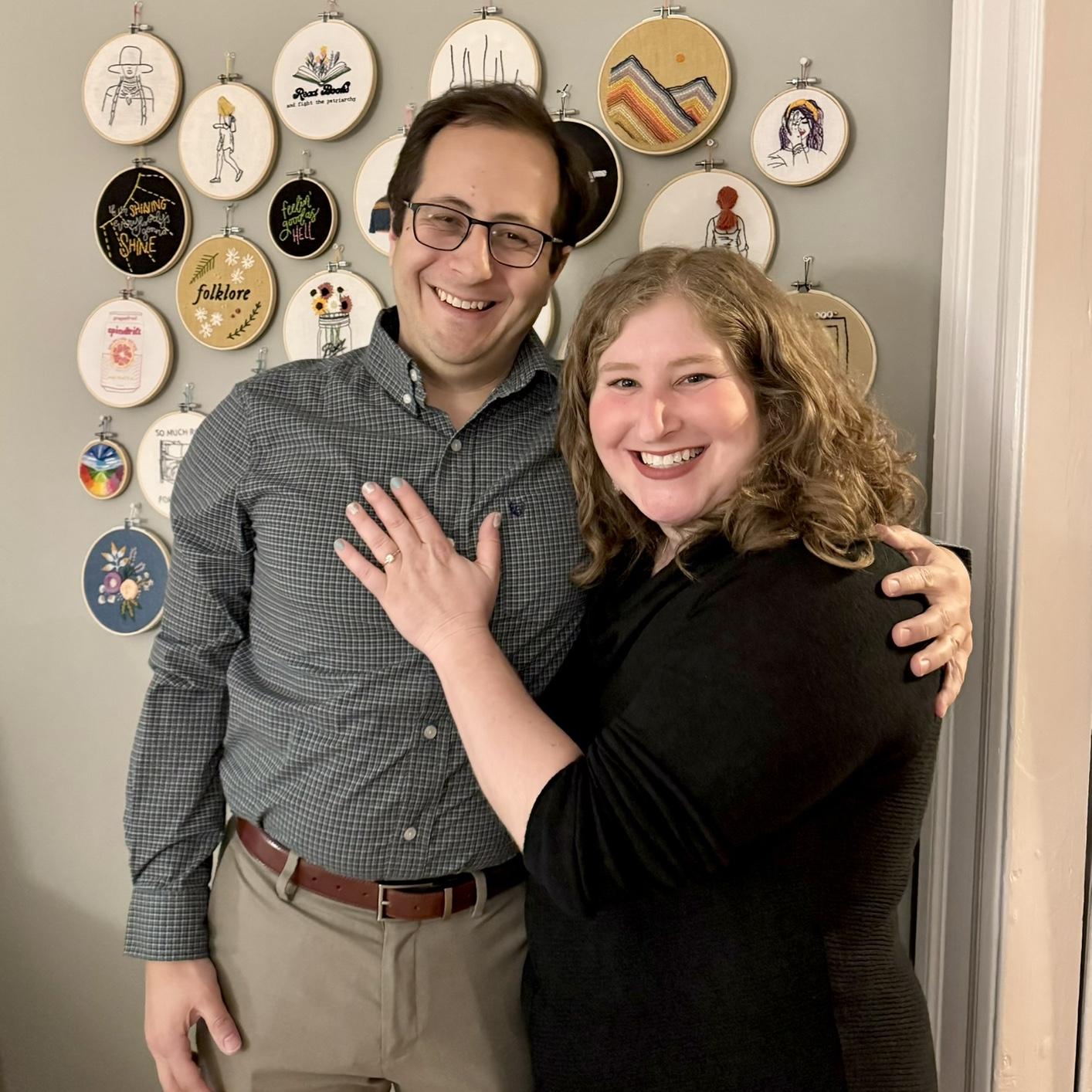 Celebrating our engagement in front of Lizzie's embroidery wall