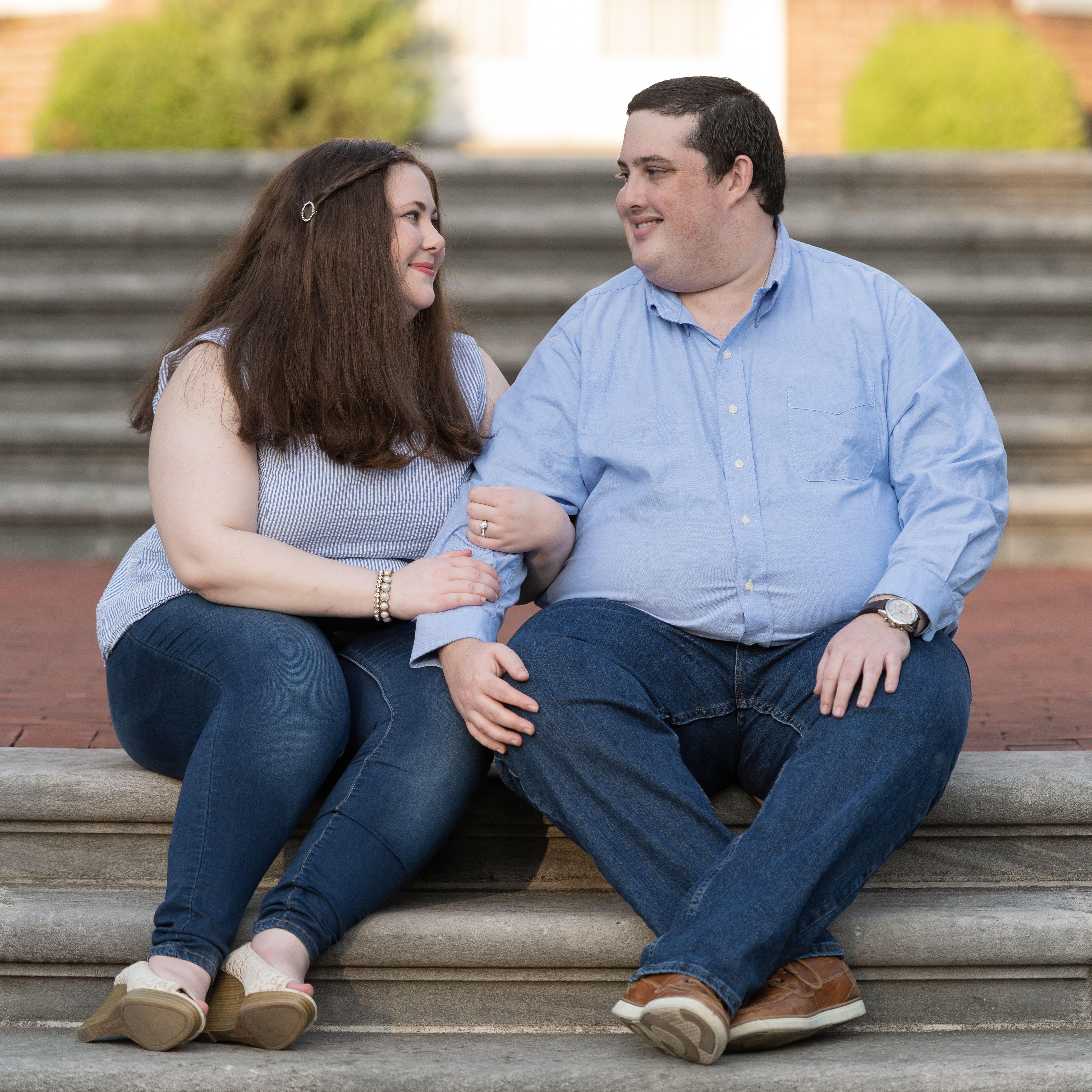 Marissa and Matt sitting on stairs, linking arms, and looking at each other