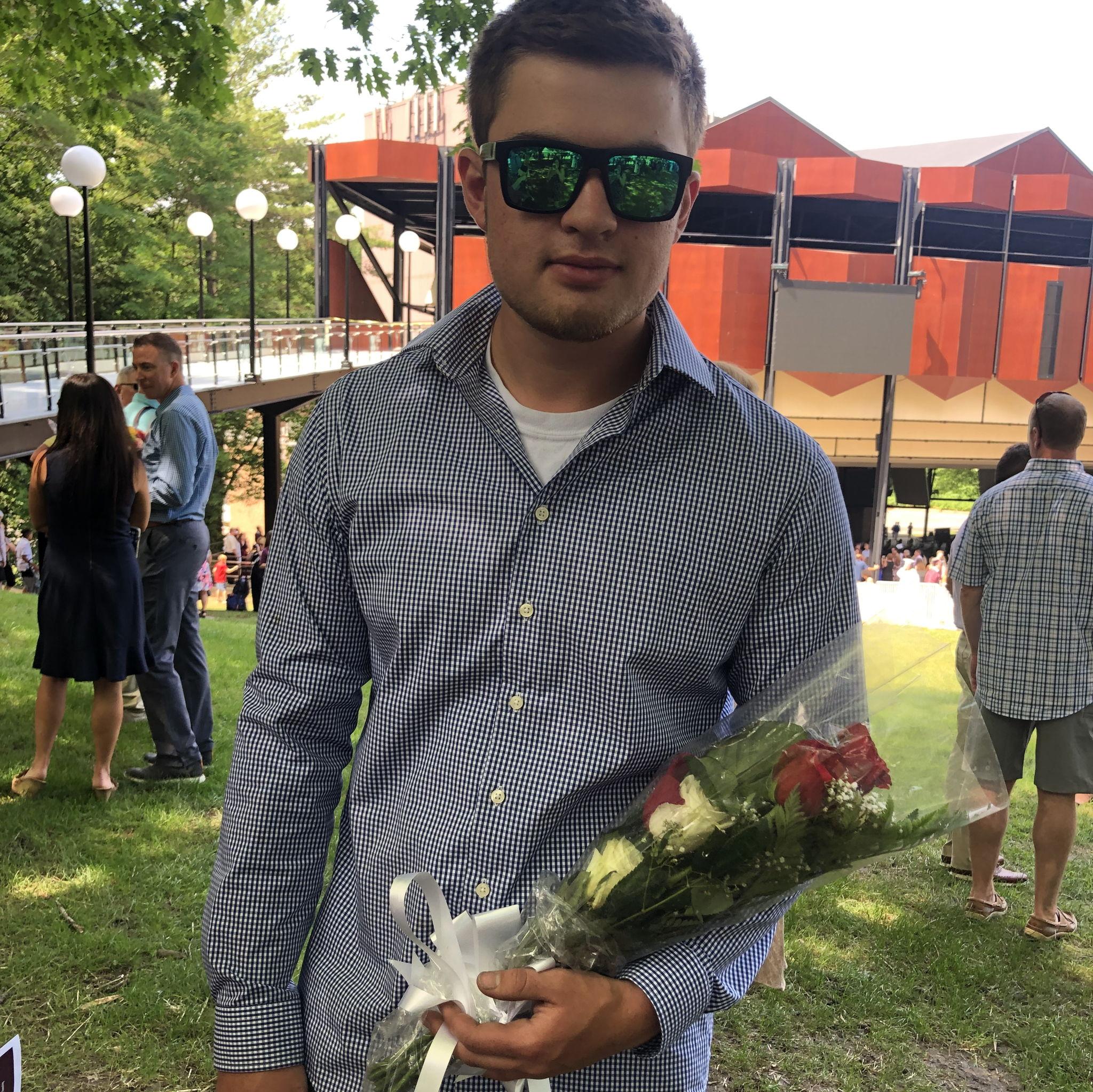 Zack giving Megan flowers after high school graduation