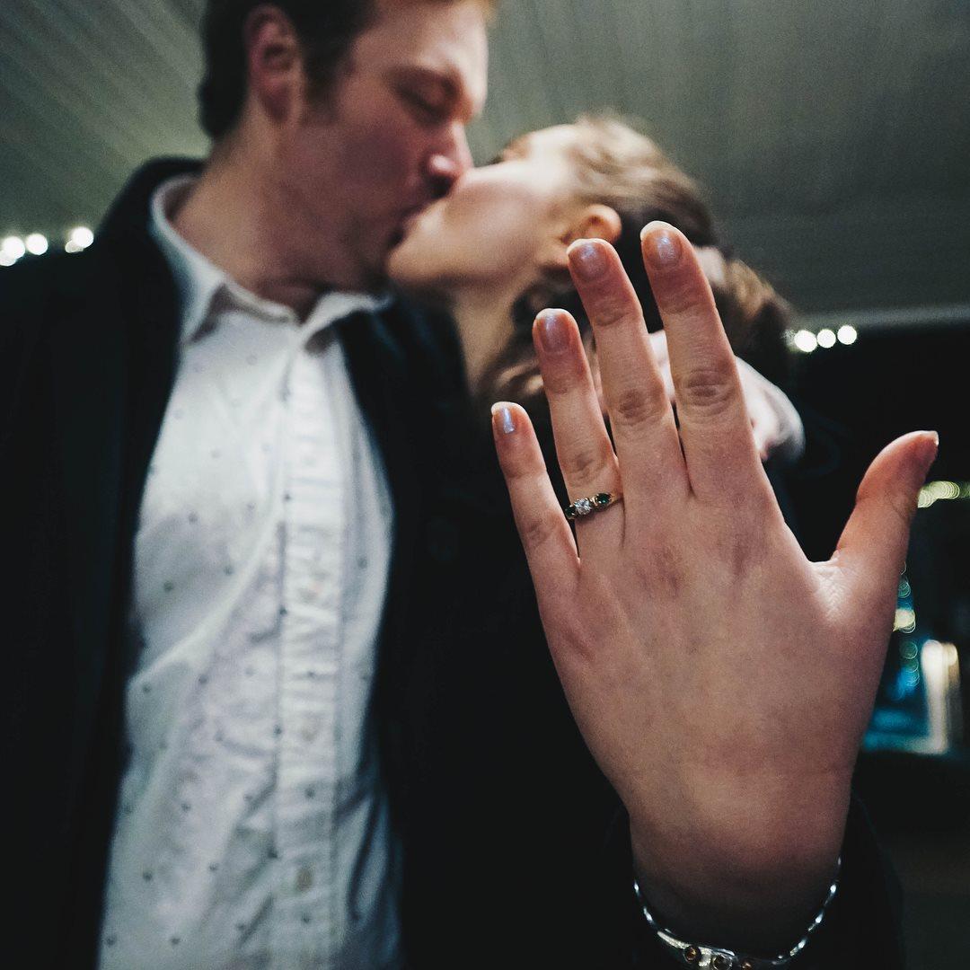 Lauren flashes the custom made ring with ancestral stones while the couple shares a kiss