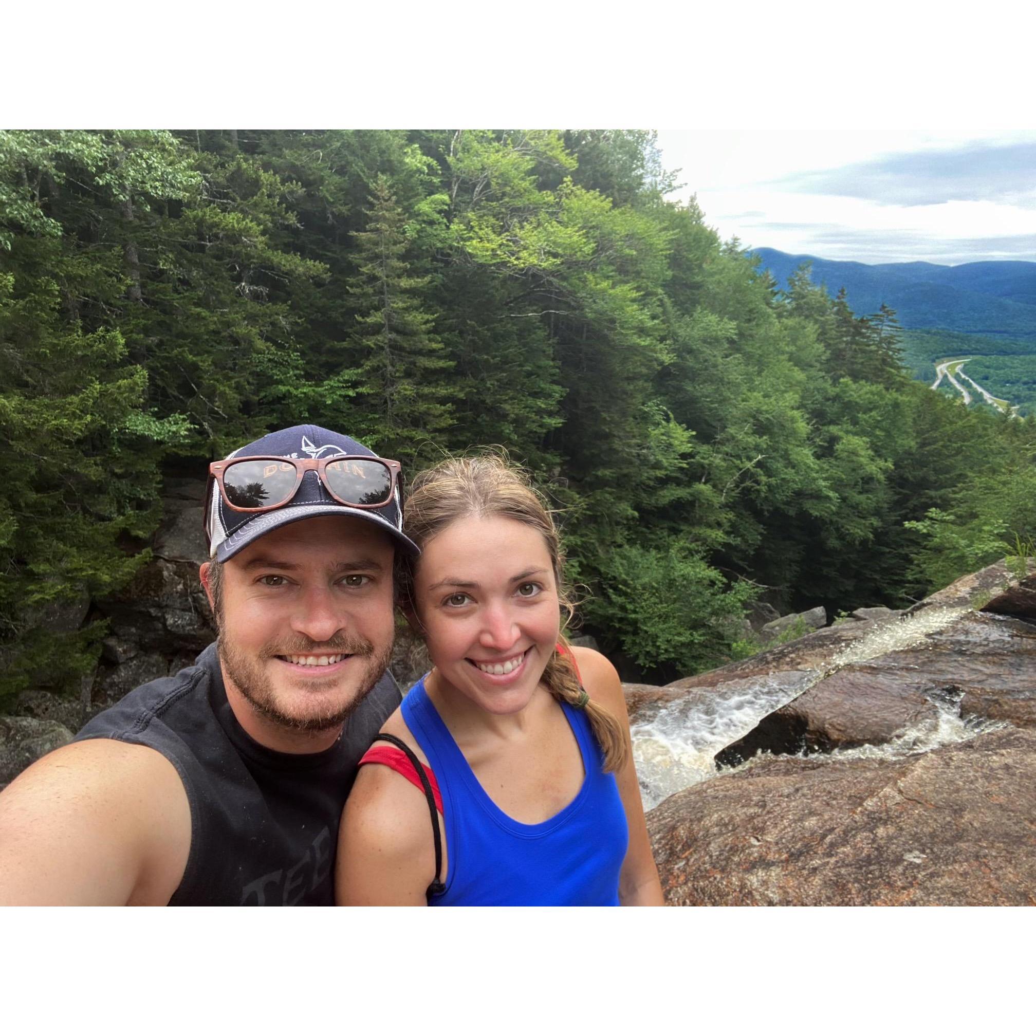 Hiking in NH, standing on the edge of a waterfall.