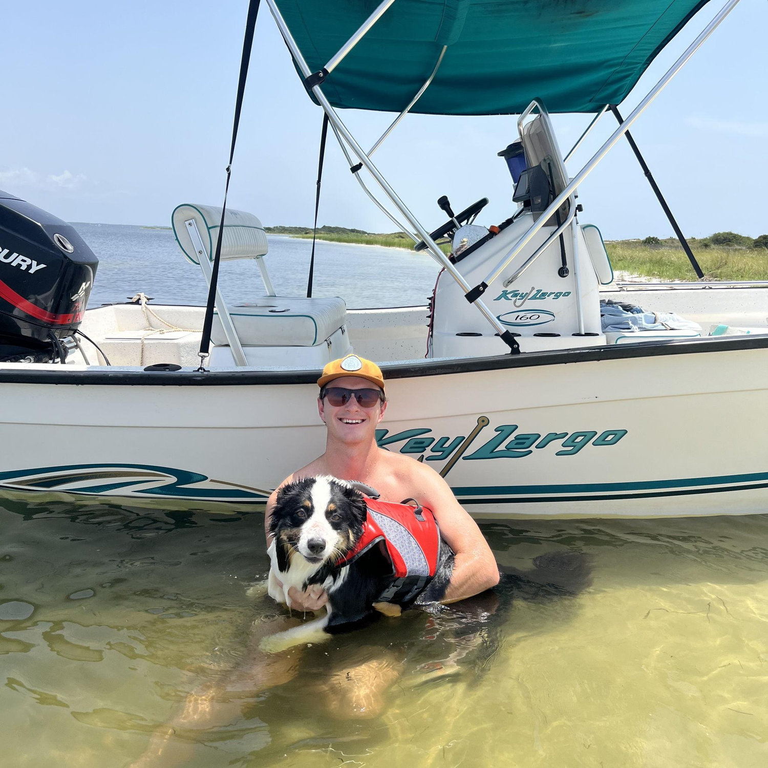 Collin with our aussie named Birdie and our boat!