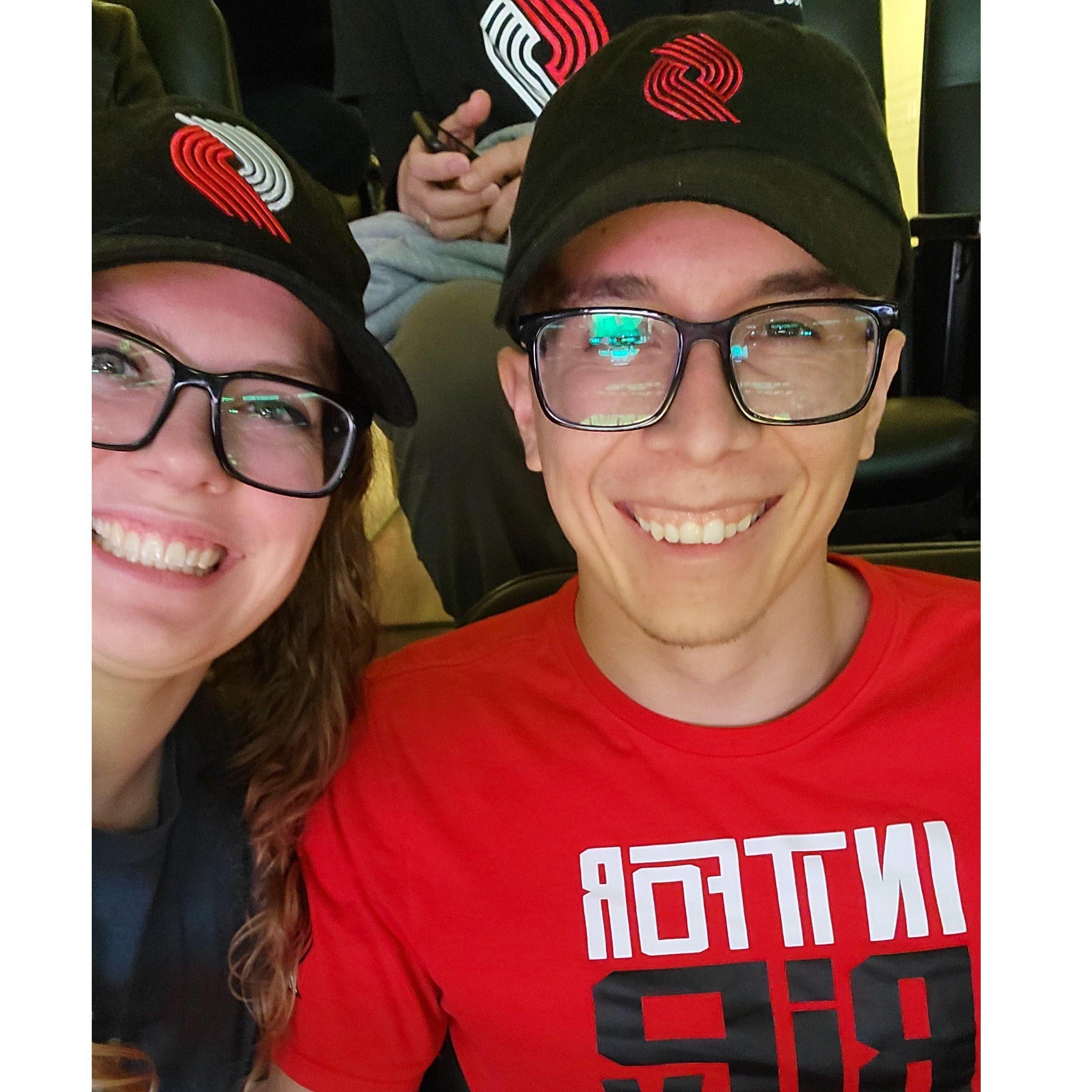 We love going to sporting events together. This is us at a Blazer game. - 2023