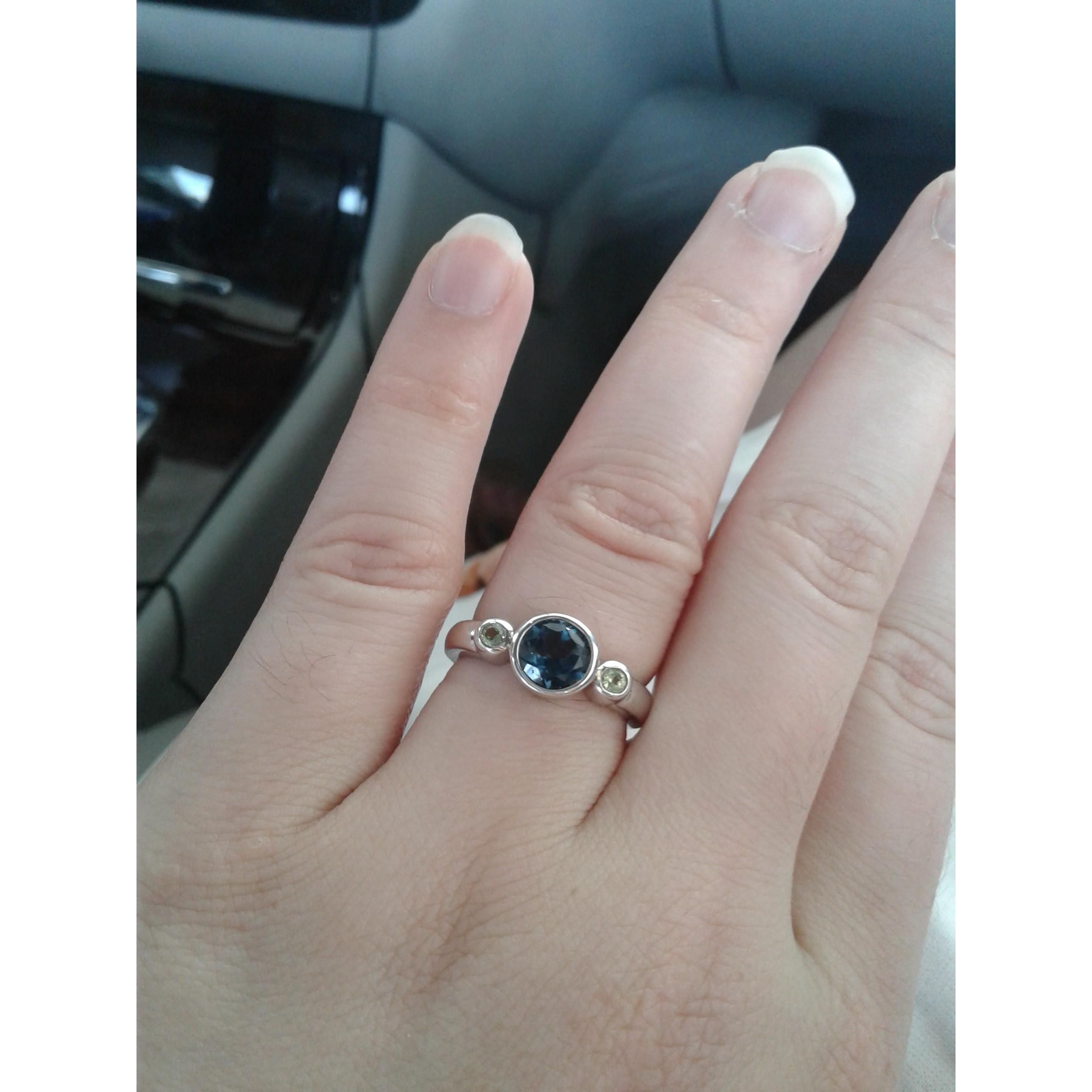 The blue stone is a London blue topaz. The two side stones are peridot, Ray's birthstone.