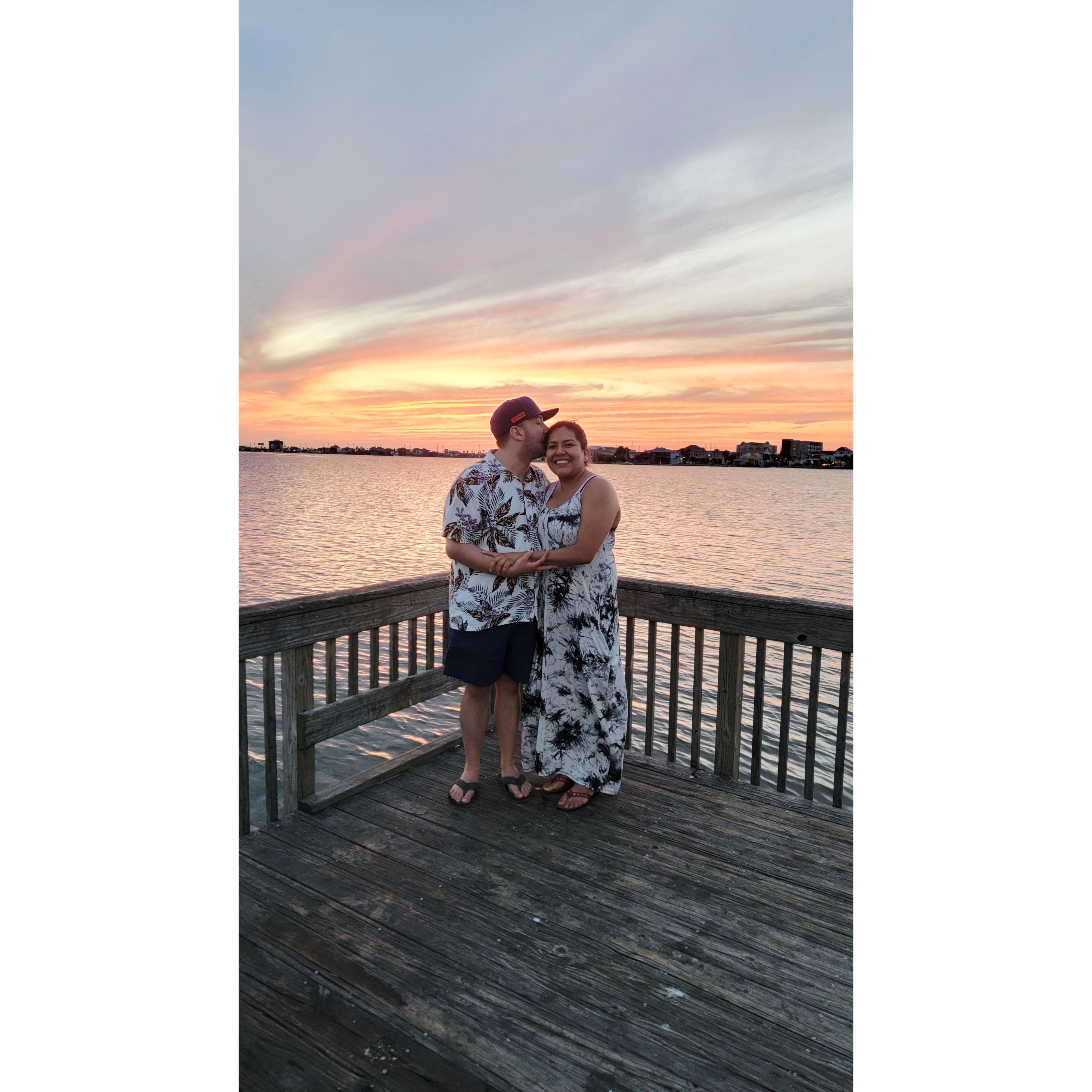 After a perfect day grilling on Galveston Beach, we paused at the dock to capture the stunning sunset. A kind stranger took our photo, seeing the love and good vibes we shared.
