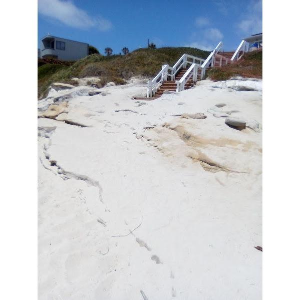 The stairs we would walk down to get the sand. There are boulders to walk over get there. I suggest wearing sandals or going barefoot.